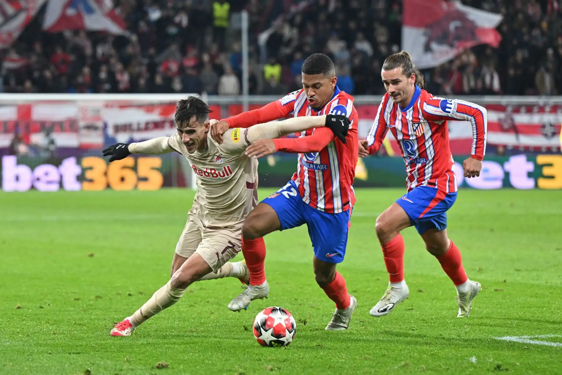 El delantero brasileño del Atlético de Madrid, Samuel Dias Lino, y el delantero francés del Atlético de Madrid, Antoine Griezmann , compiten por el balón con el mediocampista argentino del Salzburgo, Nicolás Capaldo, durante el partido de fútbol de la UEFA Champions League RB Salzburg vs Atlético de Madrid.  Foto: ANDINA/AFP