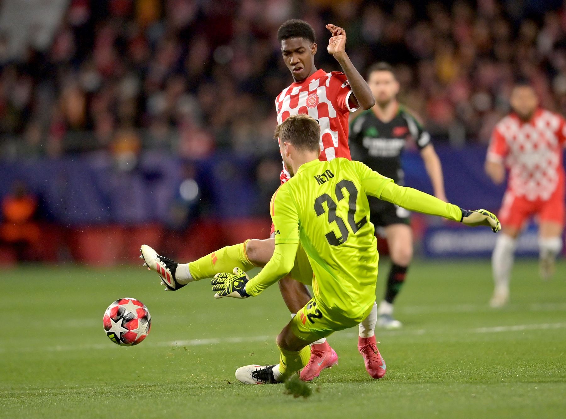 El mediocampista colombiano de Girona Yaser Asprilla desafía al portero brasileño del Arsenal  Neto durante la Liga de Campeones de la UEFA, partido de fútbol de fase liguera entre Girona FC y Arsenal FC. AFP