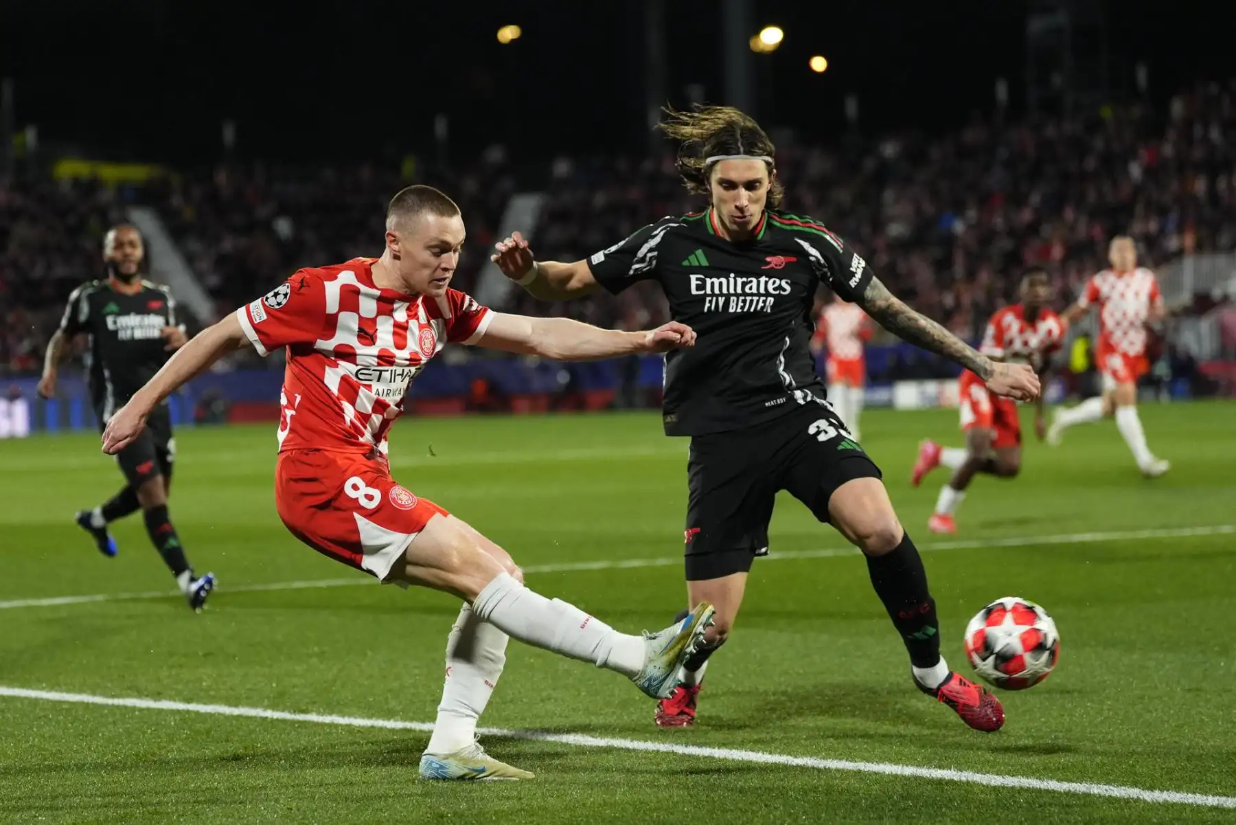 El delantero ucraniano del Girona Viktor Tsygankov disputa un balón ante el defensa italiano del Arsenal Riccardo Calafiori  durante el partido de la Liga de Campeones que Girona FC y Arsenal FC . Foto: EFE