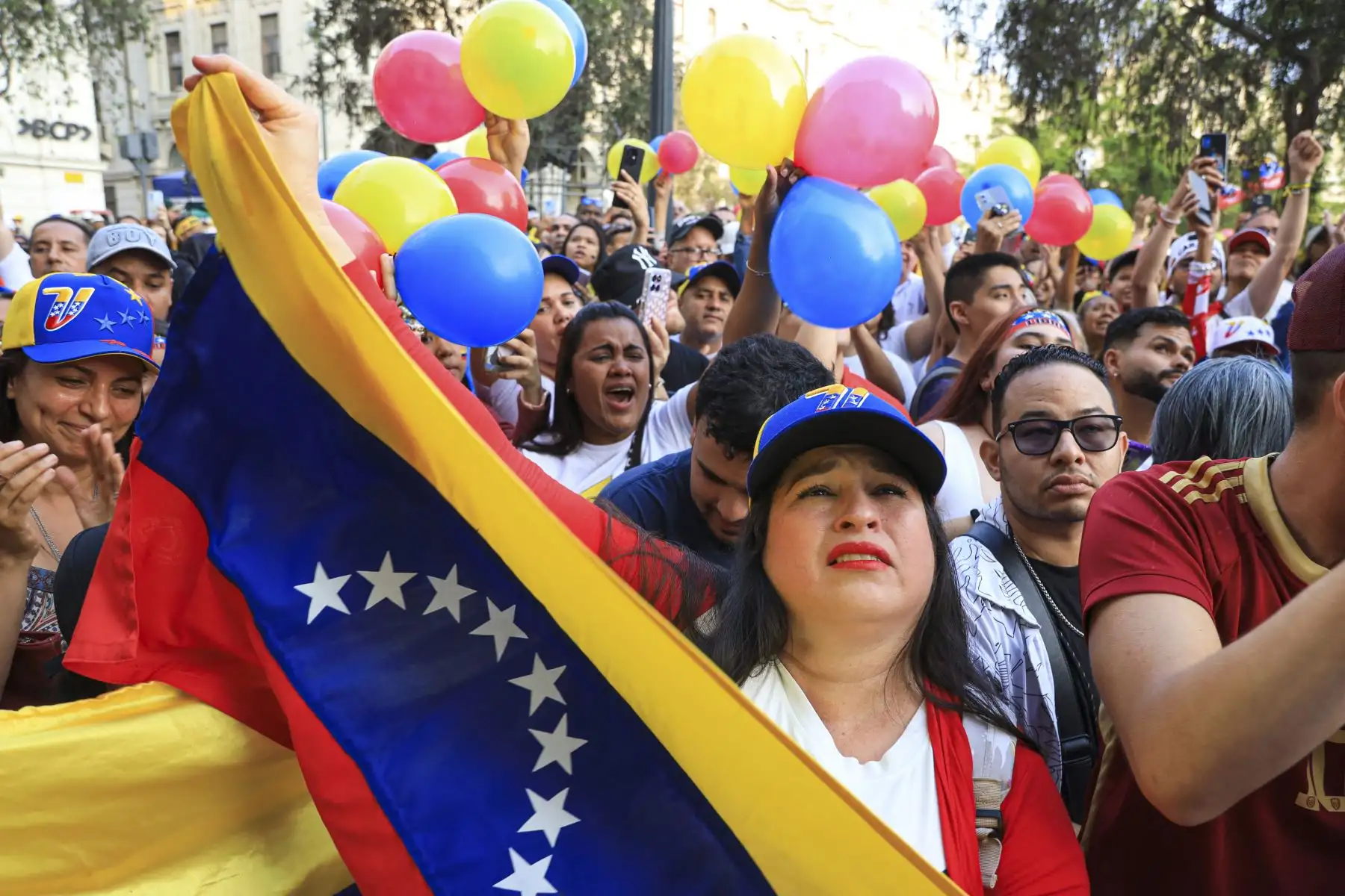 Ciudadanos venezolanos sostienen banderas venezolanas mientras participan en una manifestación a favor del líder opositor Edmundo González Urrutia en Lima. AFP