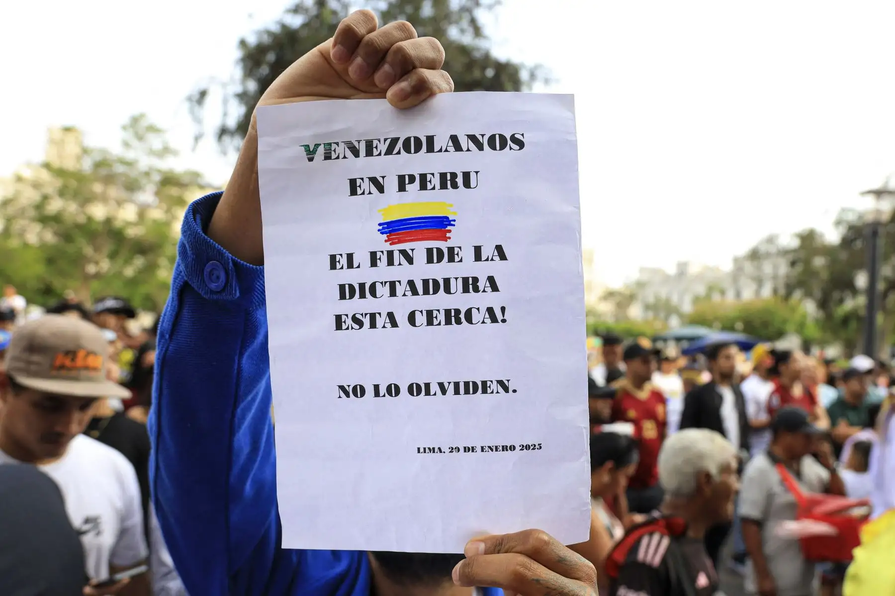 Un ciudadano venezolano sostiene un cartel que dice en español "Venezolanos en Perú, el fin de la dictadura está cerca, no lo olviden", mientras participa en una manifestación a favor de Edmundo González Urrutia en Lima. AFP