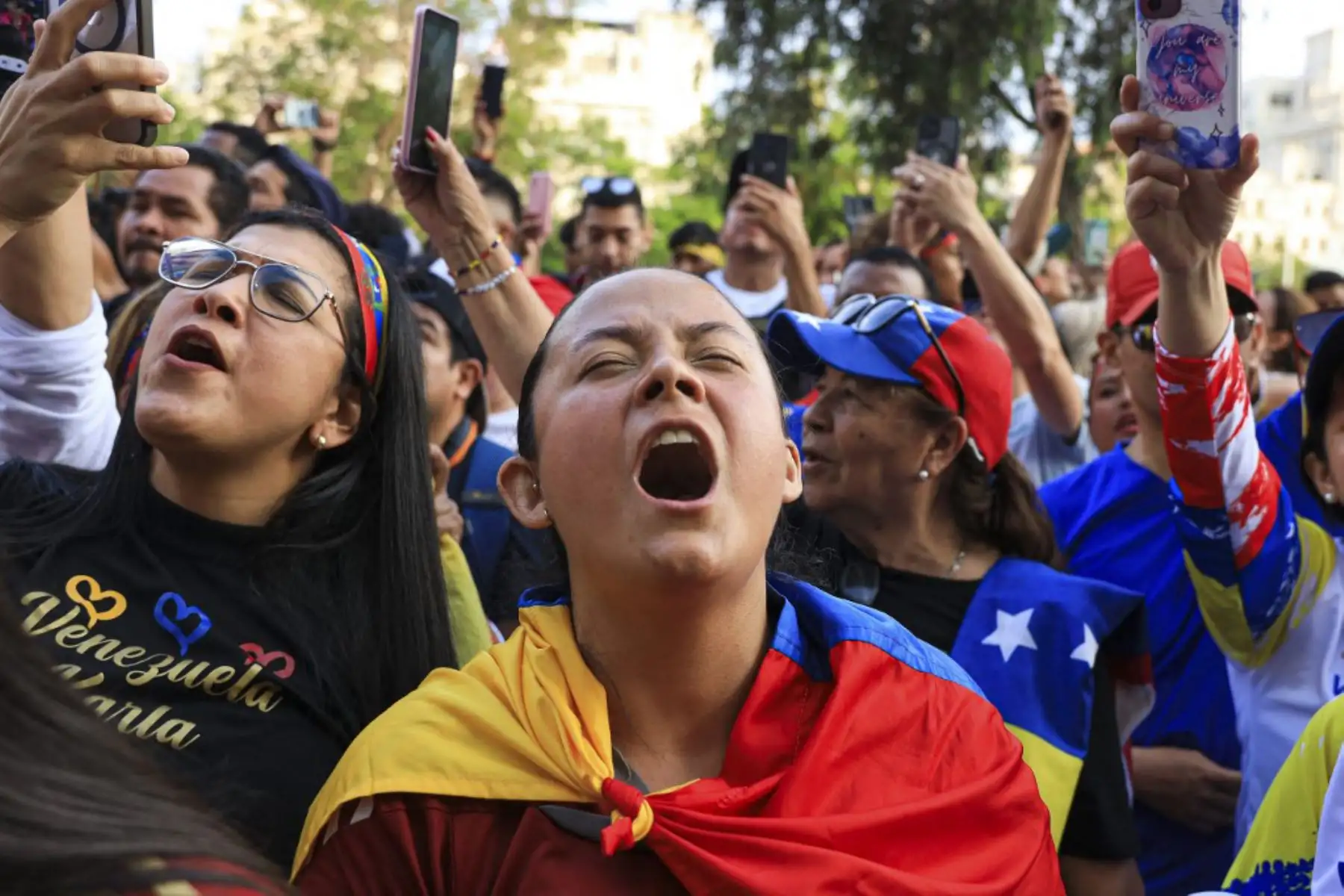 Ciudadanos venezolanos sostienen banderas venezolanas mientras participan en una manifestación a favor del presidente electo de Venezuela,  Edmundo González Urrutia. Foto: AFP