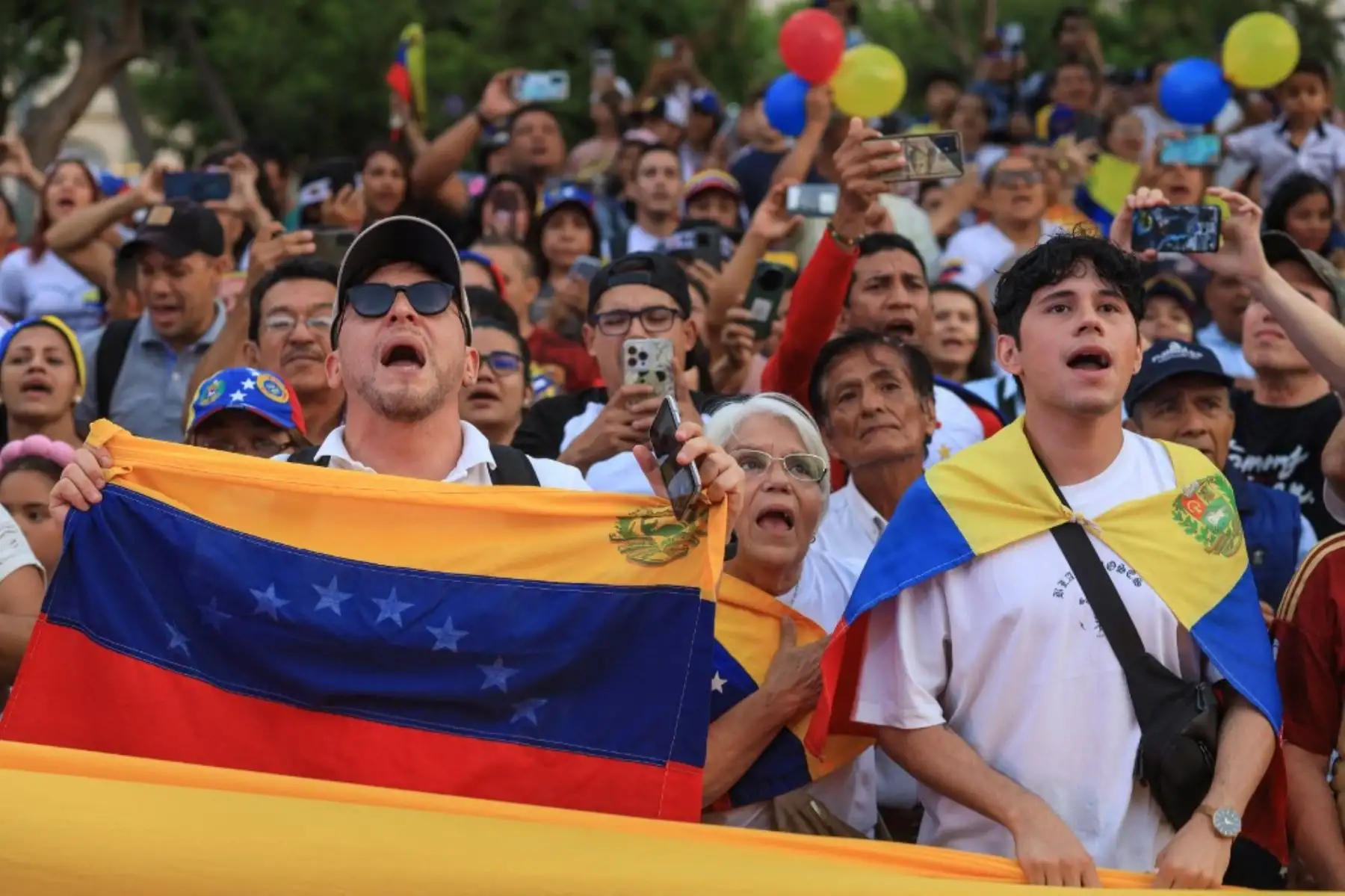 Ciudadanos venezolanos sostienen banderas venezolanas mientras participan en una manifestación a favor del presidente electo de Venezuela,  Edmundo González Urrutia. Foto: AFP