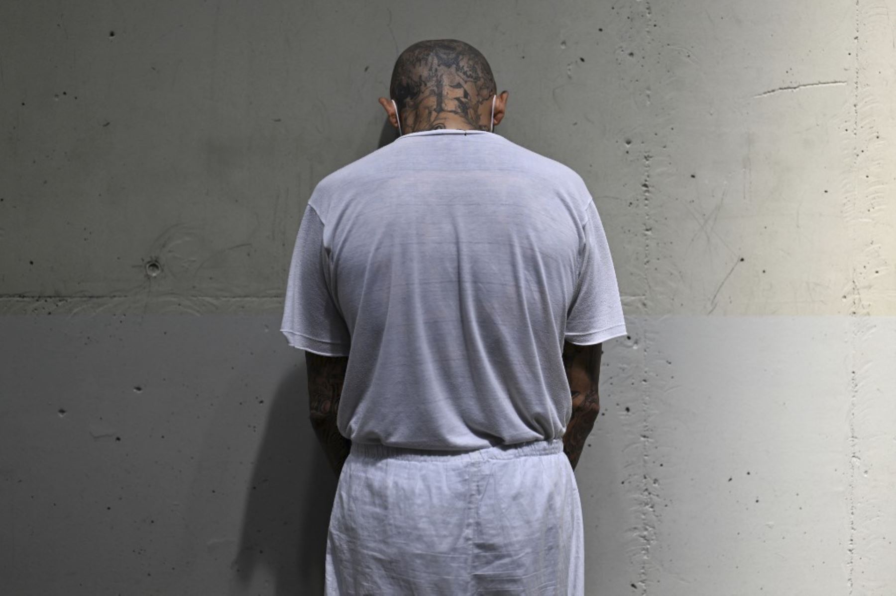 Un recluso permanece en una celda en la megaprisión del Centro de Confinamiento Antiterrorista (CECOT), donde cientos de miembros de las pandillas MS-13 y 18 Street están detenidos, en Tecoluca, El Salvador. La CECOT, la prisión más grande de América Latina y emblema de la guerra contra las pandillas del gobierno del presidente Nayib Bukele, celebra dos años desde que se inauguró el 1 de febrero. (Foto de Marvin RECINOS / AFP)