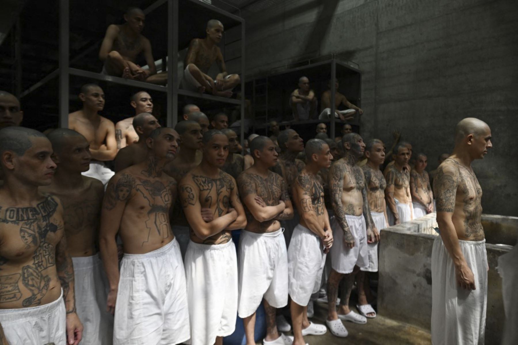 Los reclusos permanecen en una celda en la megaprisión del Centro de Confinamiento Antiterrorista (CECOT), donde cientos de miembros de las pandillas de MS-13 y 18 Street están detenidos, en Tecoluca, El Salvador. La CECOT, la prisión más grande de América Latina y emblema de la guerra contra las pandillas del gobierno del presidente Nayib Bukele, celebra dos años desde que se inauguró el 1 de febrero. (Foto de Marvin RECINOS / AFP)