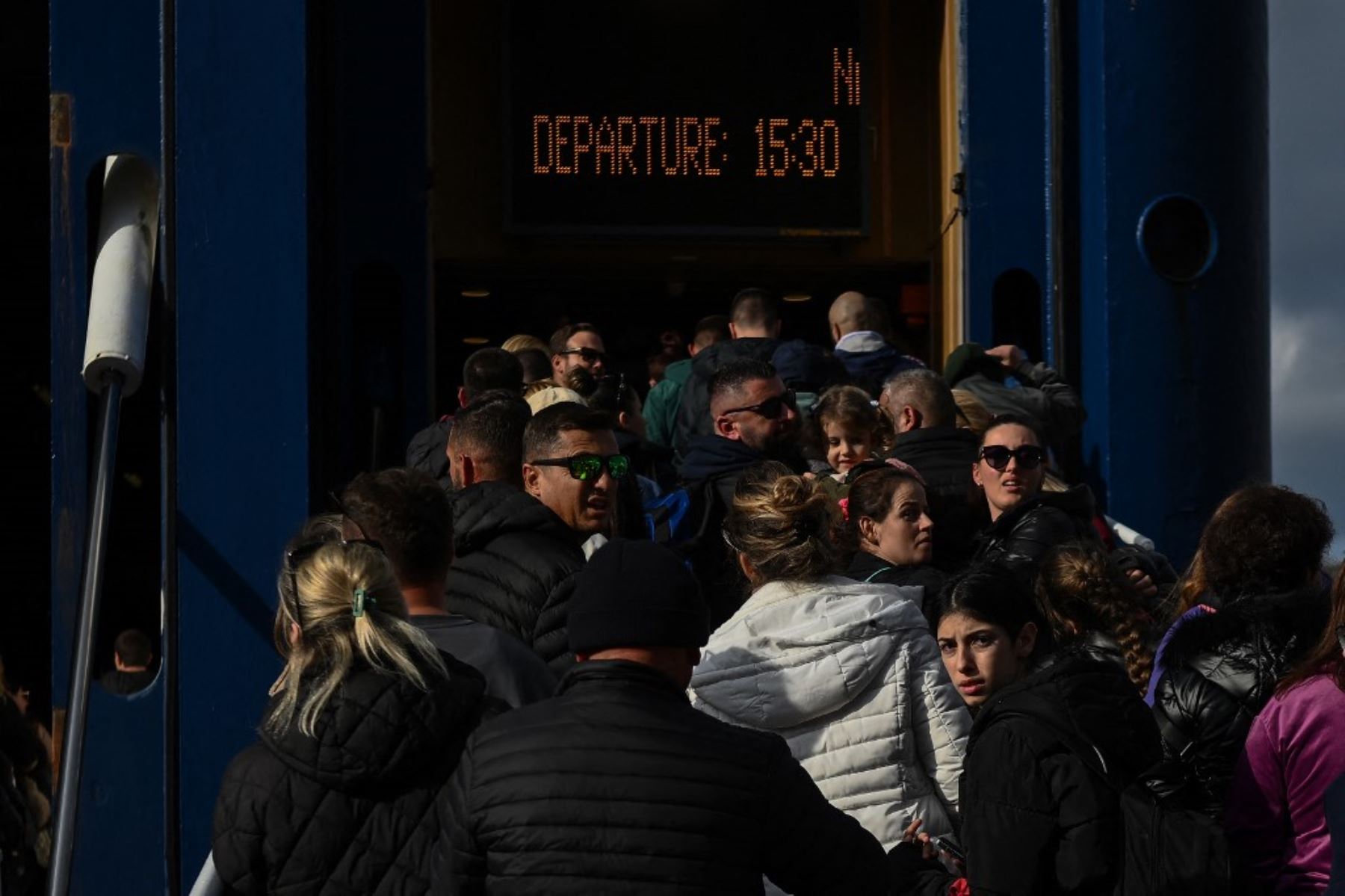 La gente espera en el muelle para embarcar en un ferry en el puerto de la isla griega de Santorini el 3 de febrero de 2025, mientras se preparan para partir tras los recurrentes sismos. Foto: AFP