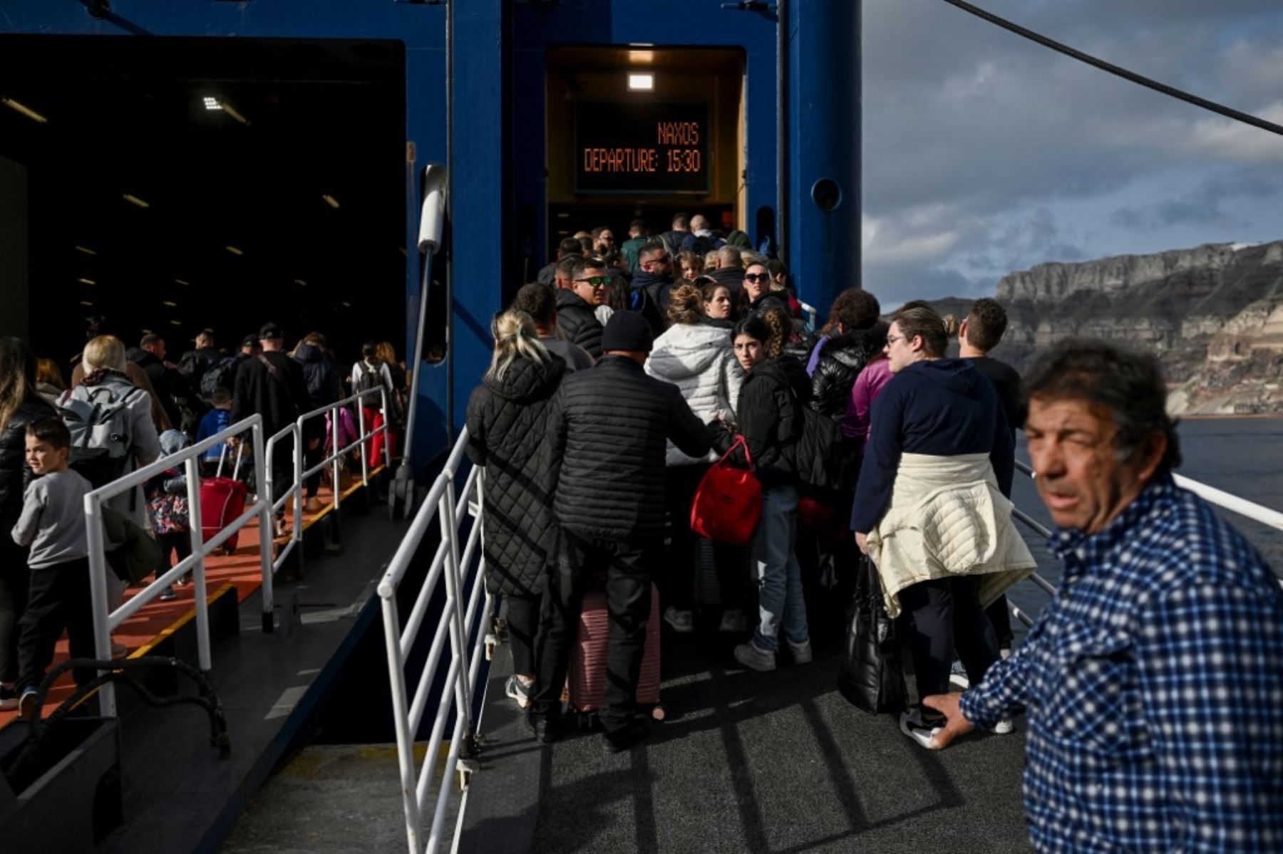 La gente espera en el muelle para embarcar en un ferry en el puerto de la isla griega de Santorini el 3 de febrero de 2025, mientras se preparan para partir tras los recurrentes sismos. Foto: AFP