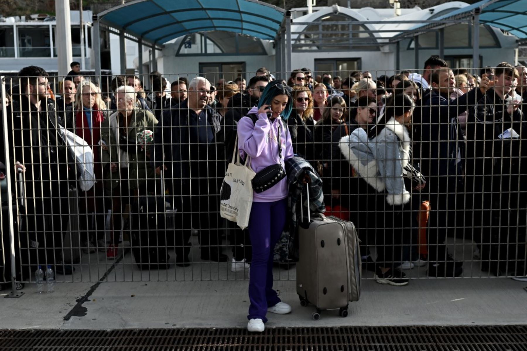 La gente espera en el muelle para embarcar en un ferry en el puerto de la isla griega de Santorini el 3 de febrero de 2025, mientras se preparan para partir tras los recurrentes sismos. Foto: AFP