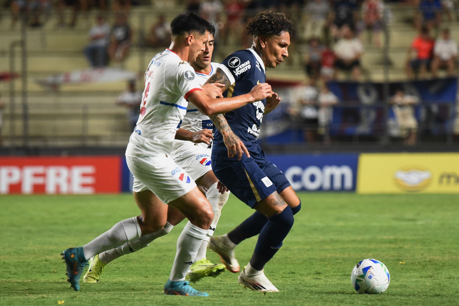 El defensor de Nacional Gastón Benítez  y el delantero de Alianza Lima  Paolo Guerrero pelean por el balón durante el partido de fútbol de ida de la primera ronda de clasificación de la Copa Libertadores entre Nacional de Paraguay y Alianza Lima de Perú.. AFP