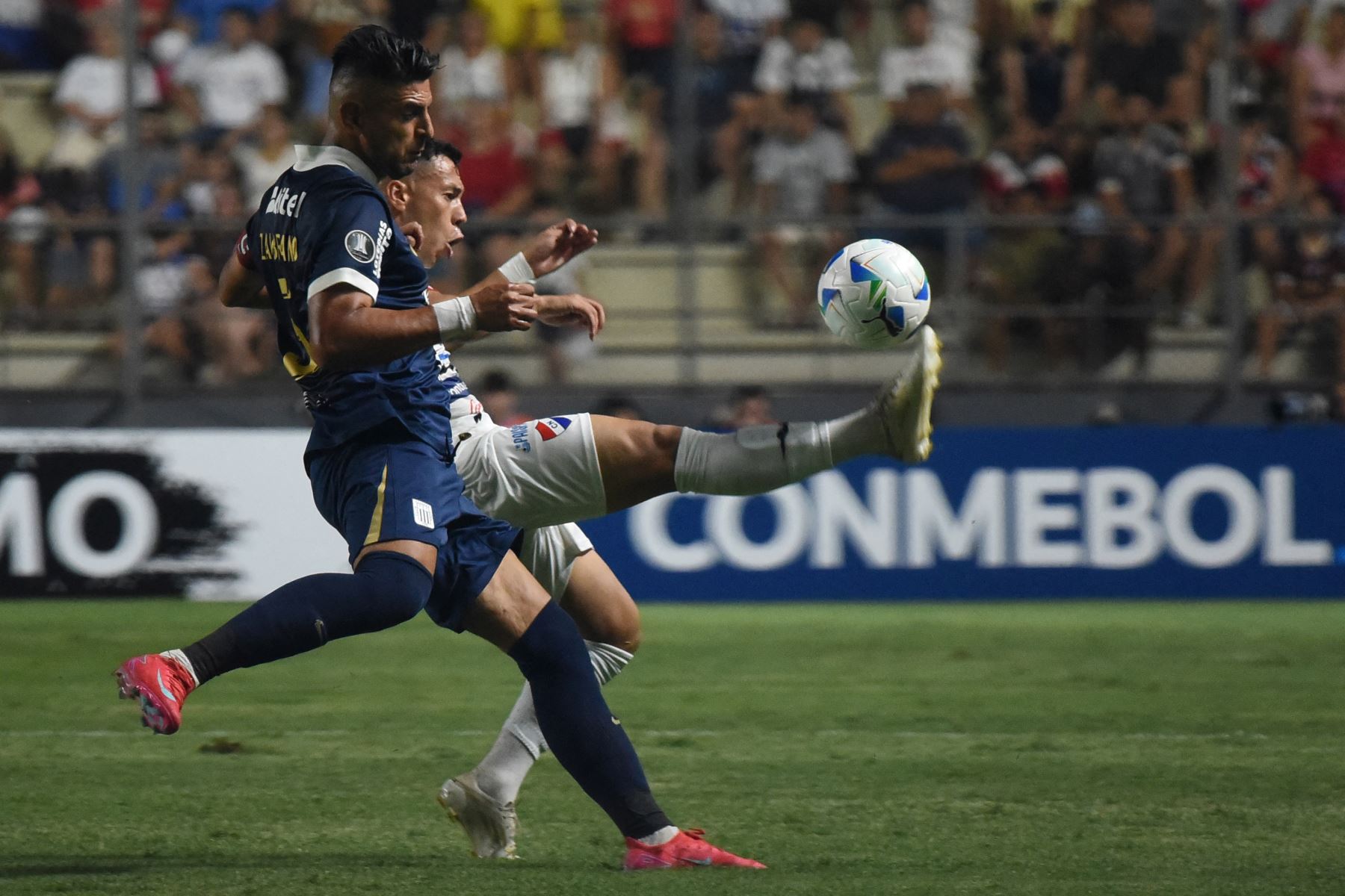 El defensor de Alianza Lima  Carlos Zambrano  y el mediocampista de Nacional  Carlos Arrua luchan por el balón durante el partido de fútbol de ida de la primera ronda de clasificación de la Copa Libertadores entre Nacional de Paraguay y Alianza Lima de Perú. AFP