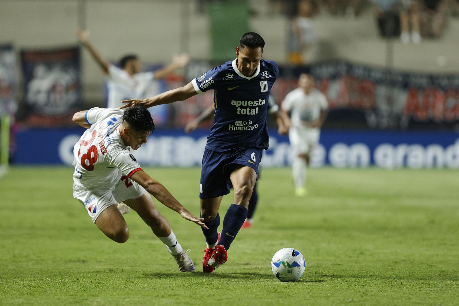 Alfredo Martínez  de Nacional disputa el balón con Renzo Garcés de Alianza Lima este miércoles, durante el partido de la fase uno de la Copa Libertadores entre Nacional y Alianza Lima. Foto: EFE