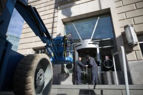 Un trabajador retira el cartel de la Agencia de los Estados Unidos para el Desarrollo Internacional de su sede en Washington D. C.  Foto: AFP