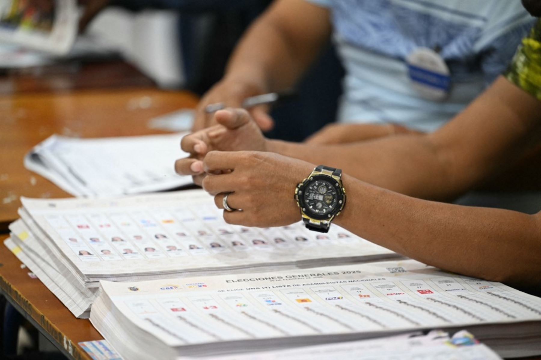 Un funcionario electoral se sienta con papeletas mientras espera a los votantes en un colegio electoral durante las elecciones presidenciales en Olon, provincia de Santa Elena, Ecuador, el 9 de febrero de 2025. Unos 14 millones de ecuatorianos comenzaron a votar el domingo para decidir quién liderará a la nación andina devastada por la violencia a través de su peor crisis en medio siglo. (Foto de Marvin RECINOS / AFP)