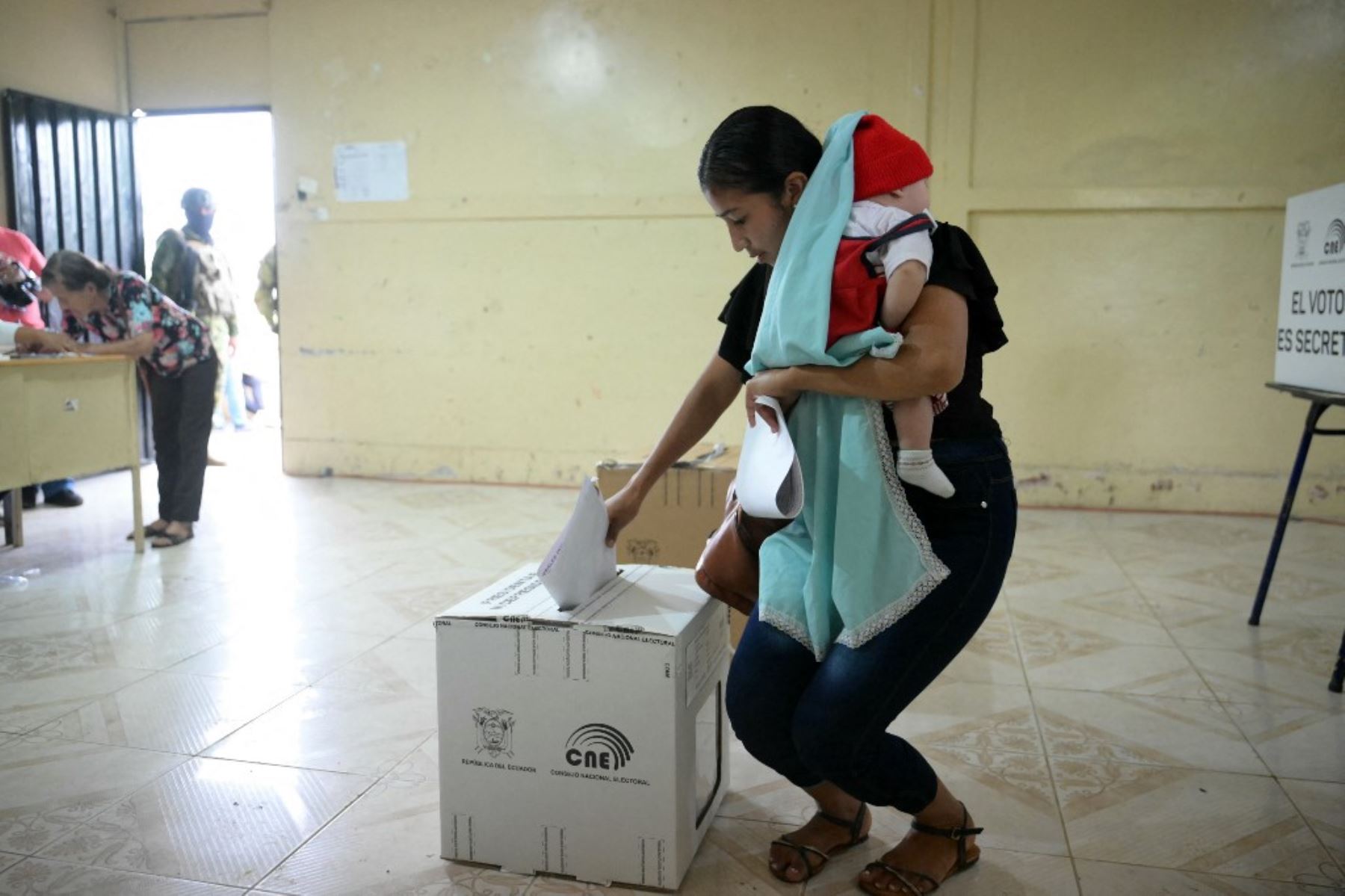 Una mujer con su bebé vota en un colegio electoral durante las elecciones presidenciales en Canuto, provincia de Manabi, Ecuador, el 9 de febrero de 2025. Unos 14 millones de ecuatorianos comenzaron a votar para decidir quién liderará a la nación andina devastada por la violencia a través de su peor crisis en medio siglo. (Foto de Rodrigo BUENDIA / AFP)