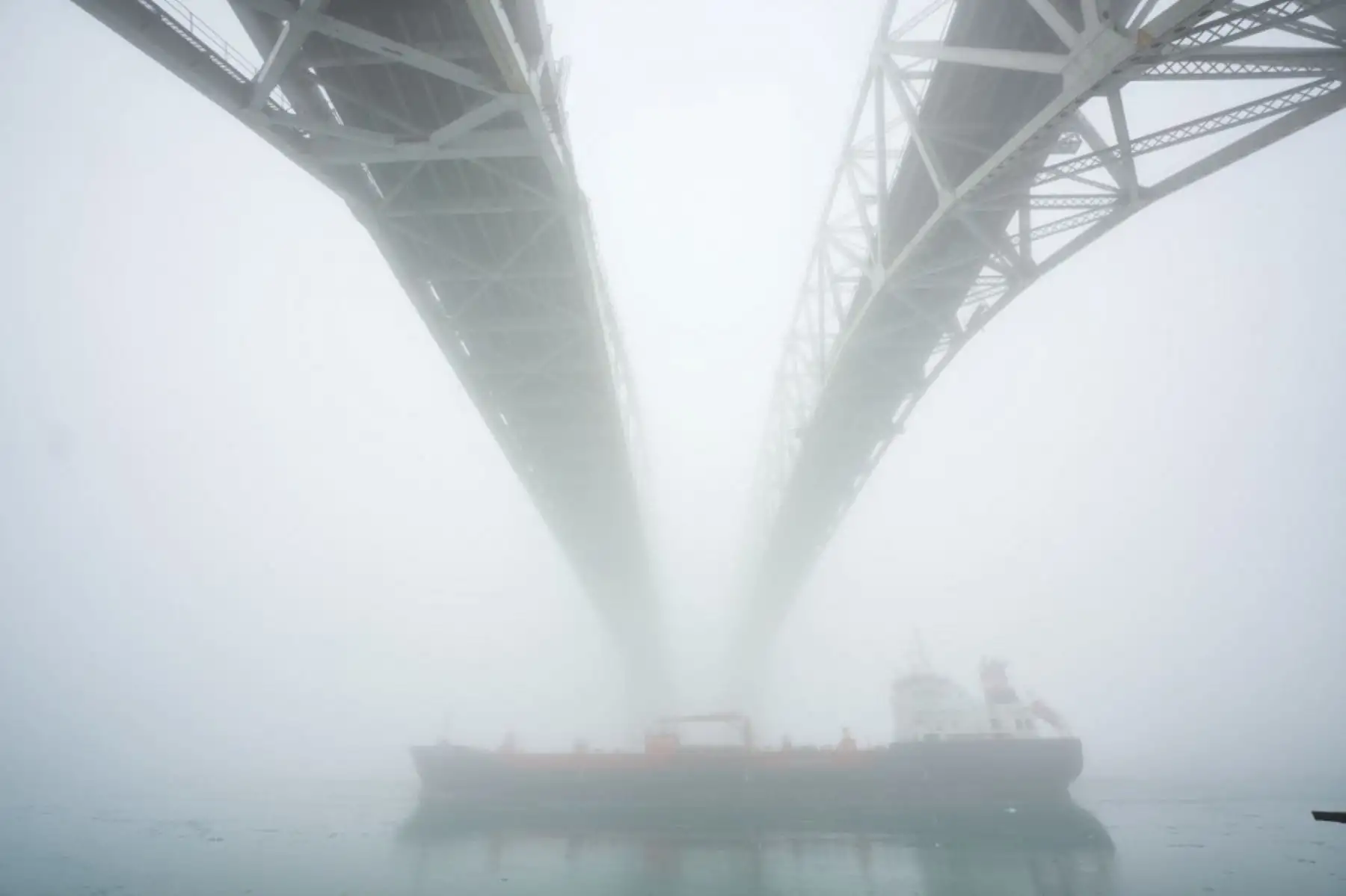 Un barco se abre paso por el St. El río Clair bajo el cruce fronterizo del Puente de Agua Azul entre Sarnia, Ontario y Port Huron, Michigan, el 3 de febrero de 2025. El presidente de los Estados Unidos, Donald Trump, dijo que discutirá los aranceles punitivos que ha impuesto a Canadá y México con ambos países el lunes, después de argumentar que los estadounidenses pueden sentir "dolor" económico por los aranceles del 25 por ciento, pero que "valdrá la pena el precio". (Foto de Geoff Robins / AFP)