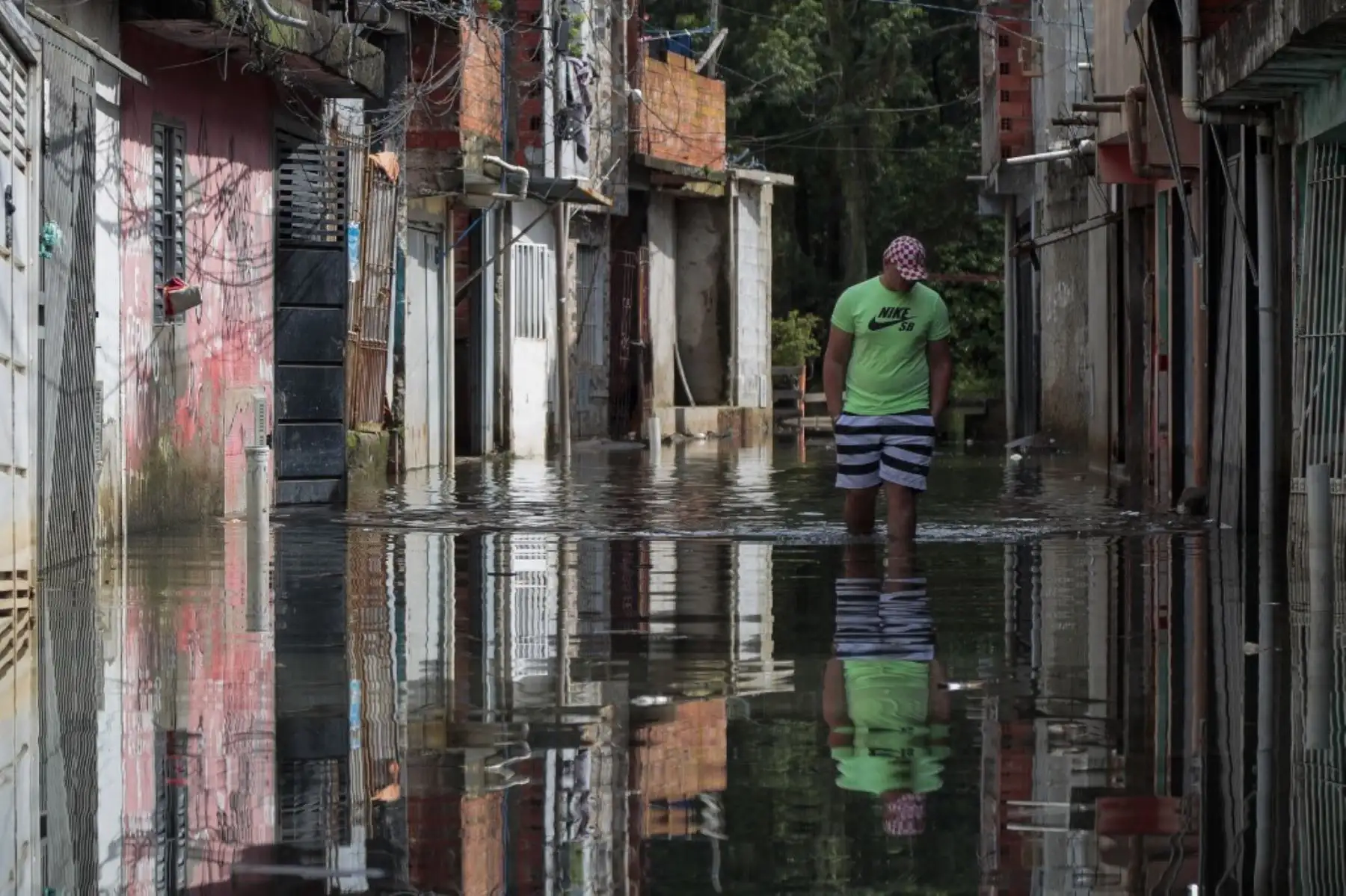 Un hombre camina por aguas inundadas en el barrio de Jardim Pantanal en Sao Paulo el 5 de febrero de 2025. Los residentes de Jardim Pantanal, un barrio de bajos ingresos en Sao Paulo, se enfrentan a inundaciones después de las fuertes lluvias del fin de semana. (Foto de Miguel SCHINCARIOL / AFP)