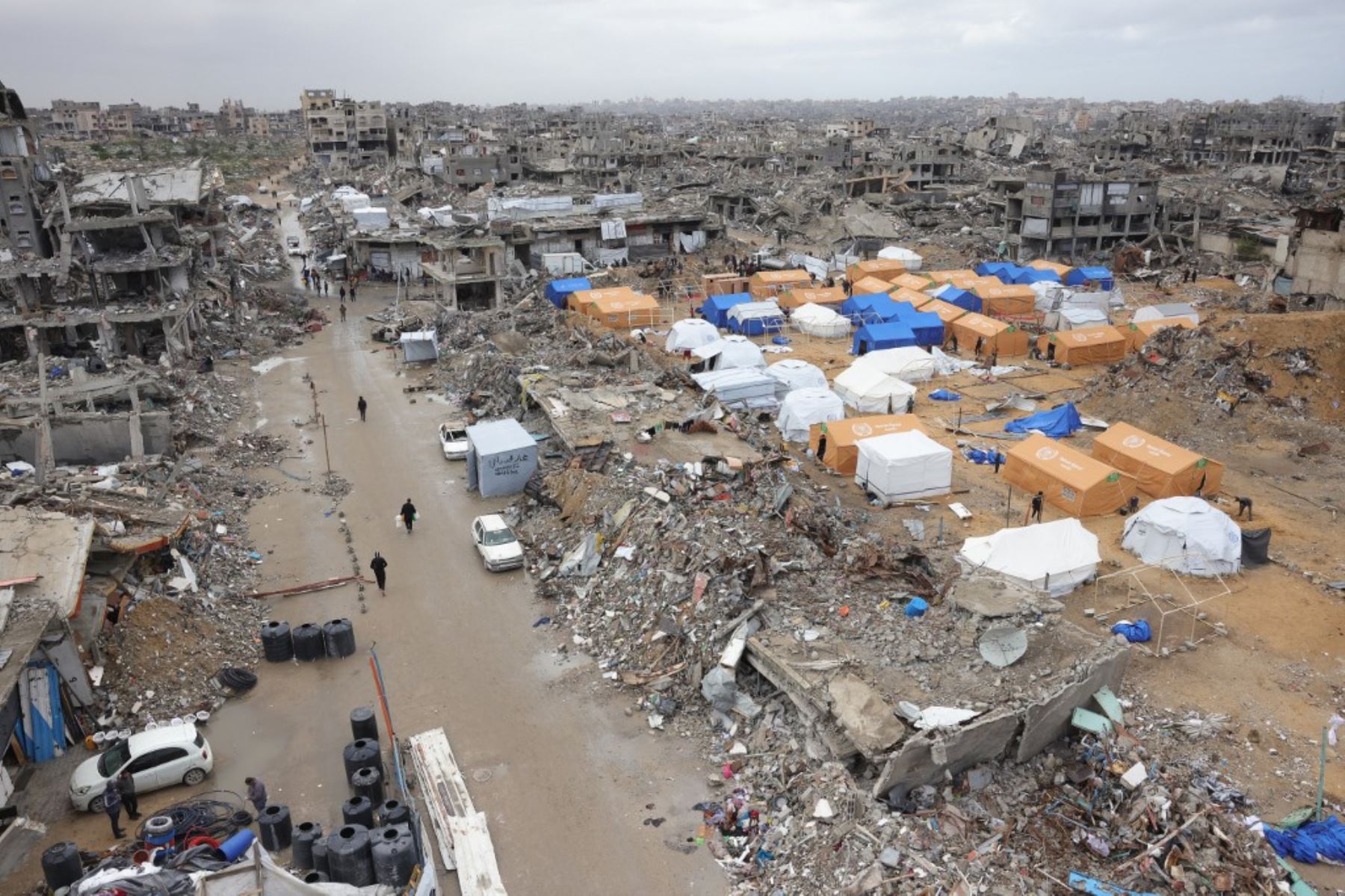 Los palestinos se refugian en tiendas de campaña montadas en medio de edificios muy dañados en Jabalia, en el norte de la Franja de Gaza, el 6 de febrero de 2025, durante una tregua en la guerra entre Israel y Hamas. En los refugios improvisados afectados por el hambre establecidos en antiguas escuelas, casas bombardeadas y cementerios en la Franja de Gaza, devastados por 15 meses de guerra entre Hamas e Israel, cientos de miles carecen incluso de láminas de plástico para protegerse de las lluvias invernales. Foto: AFP