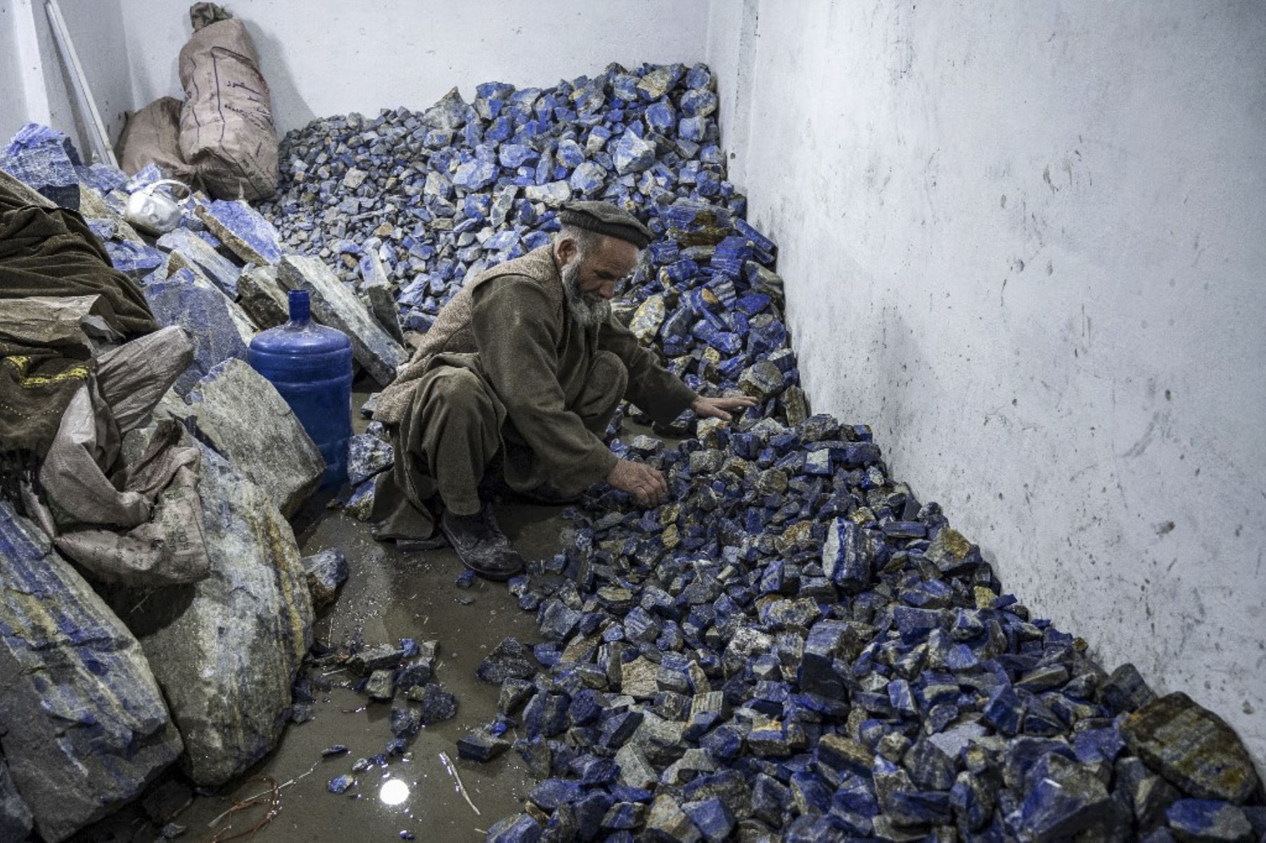 Un trabajador afgano clasifica piedras de lapislázuli en bruto utilizadas en joyería, en un taller en Kabul. Foto: AFP