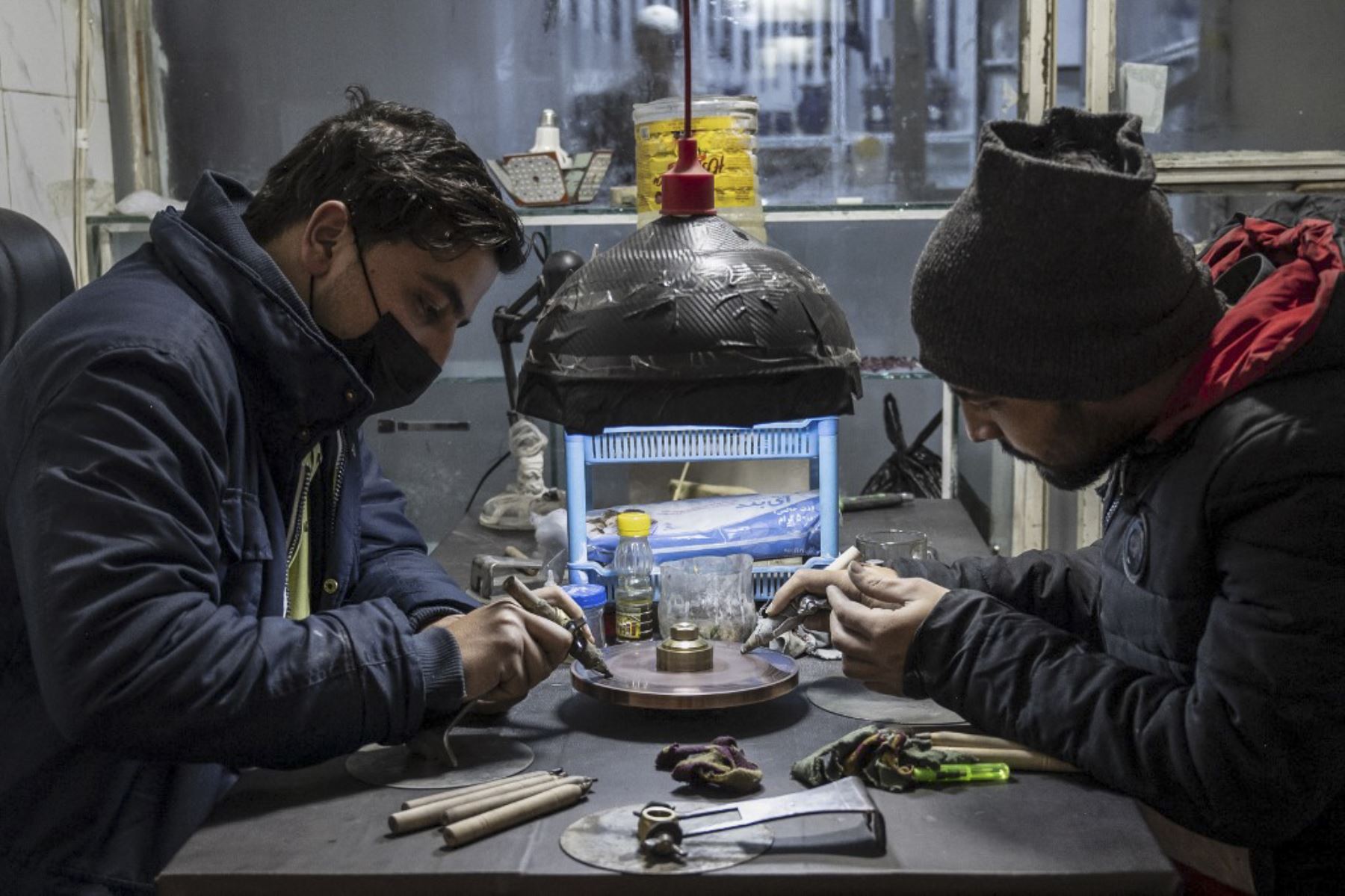 Joyeros afganos trabajando en piedras preciosas de rubí, en un taller de grabado y orfebrería en Kabul. Foto: AFP