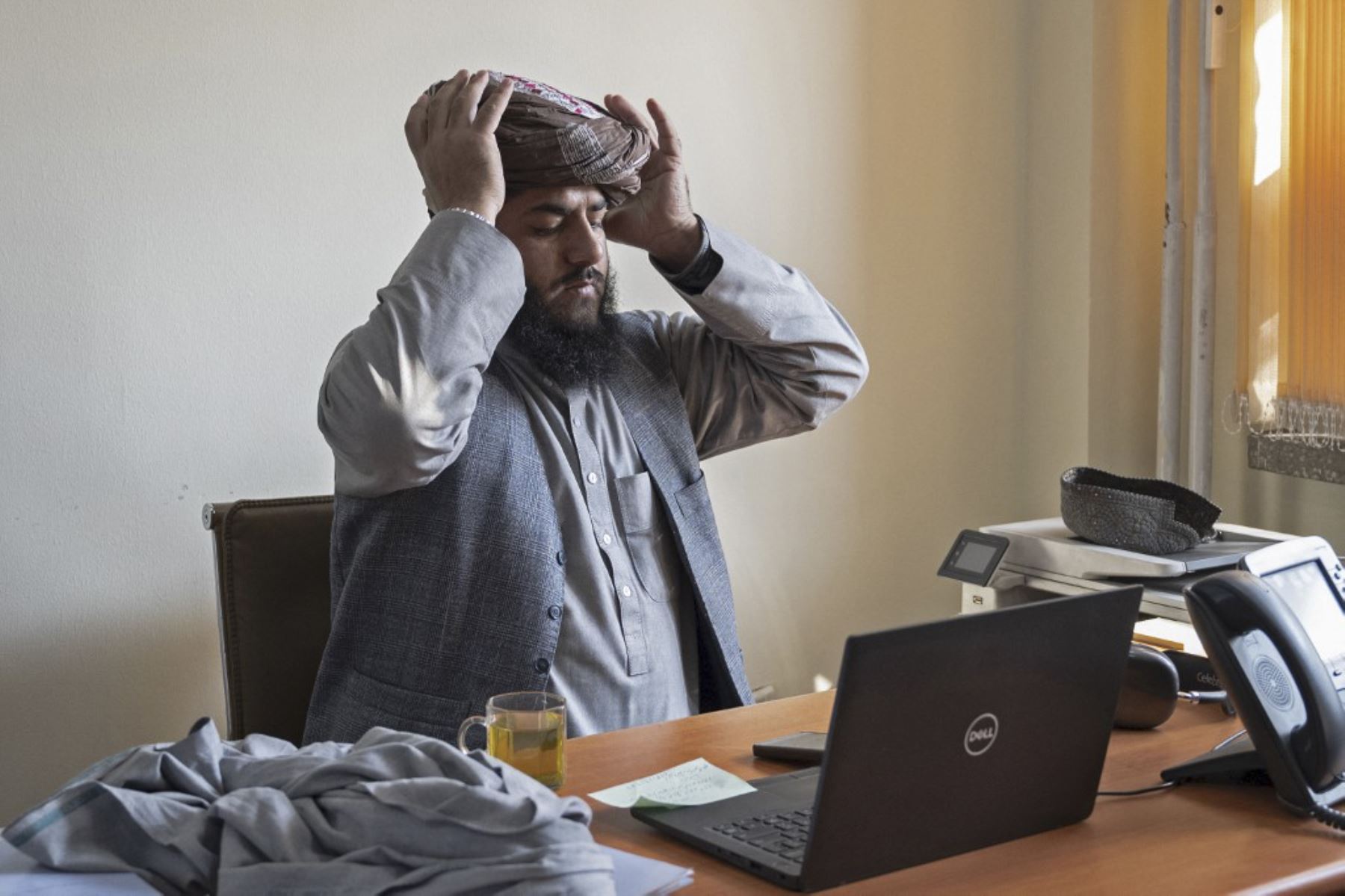 El portavoz del ministerio de minas de Afganistán, Humayoun Afghan, ajusta su turbante antes de asistir a una entrevista con AFP en su oficina en Kabul. Foto: AFP