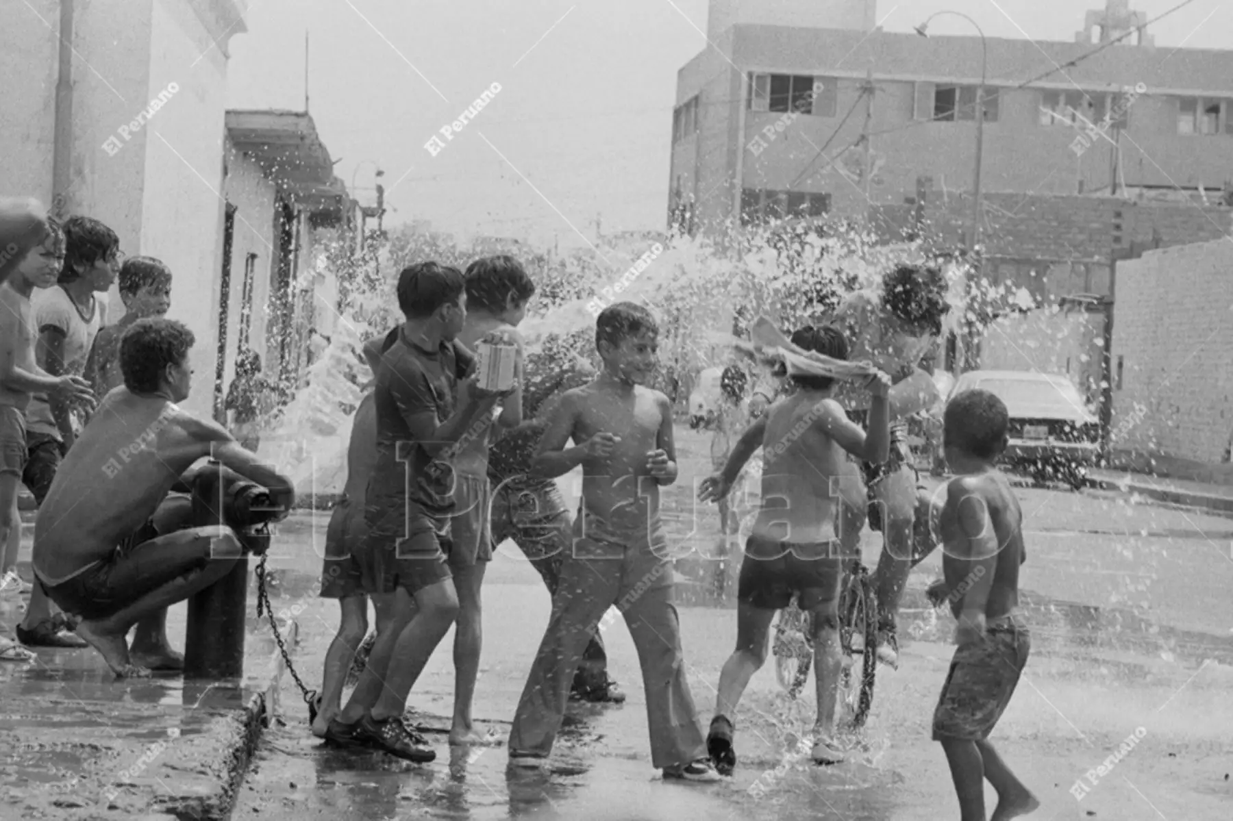 Lima - 6 febrero 1977 / Un grupo de niños y adolescentes da rienda suelta al juego carnavalesco abriendo un hidrante de incendios en un barrio capitalino. Foto: Archivo Histórico de El Peruano / Rolando Ángeles