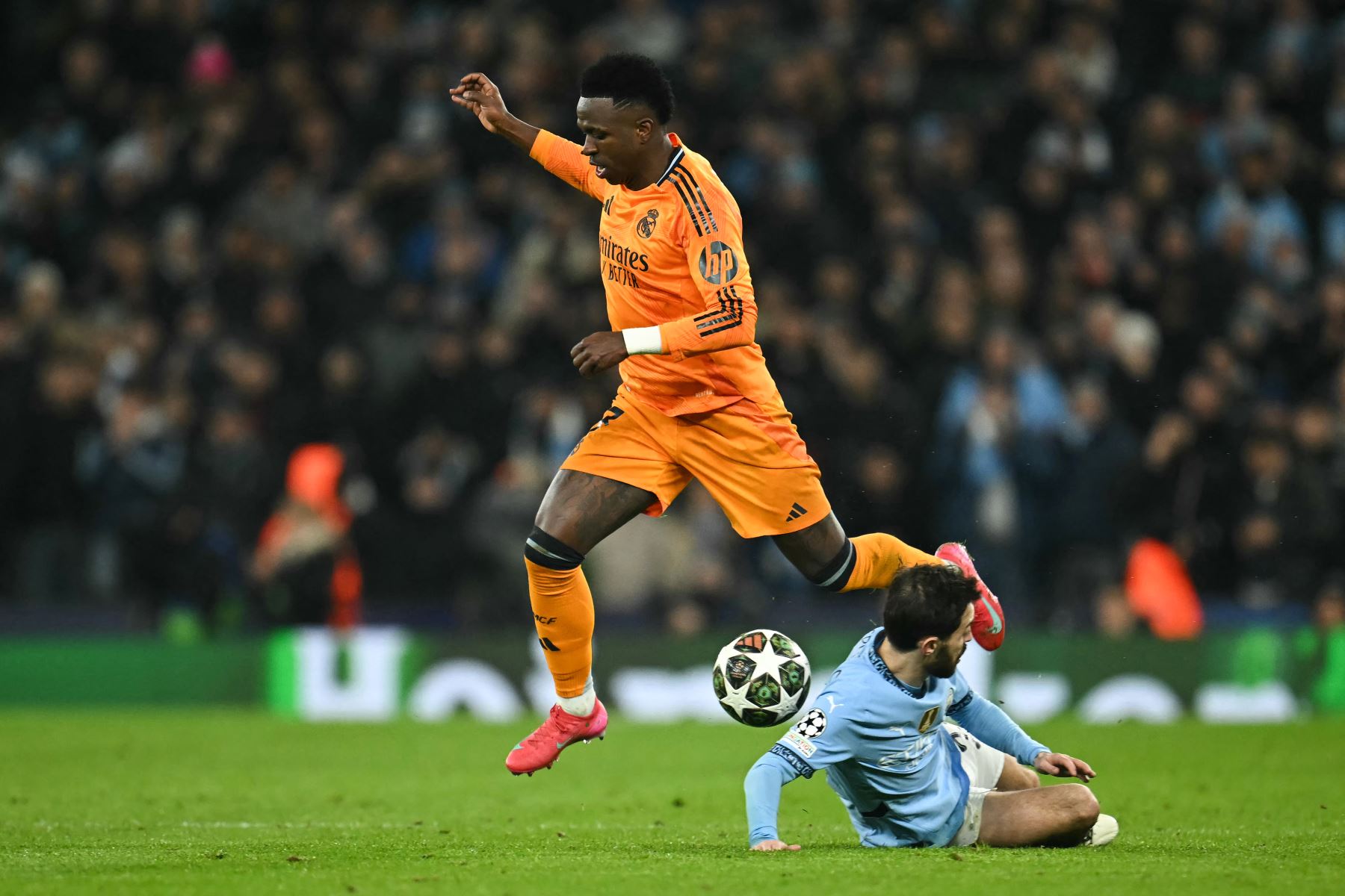 El delantero brasileño del Real Madrid, Vinicius Junior  salta sobre el centrocampista portugués del Manchester City, Bernardo Silva durante el partido de fútbol de la Liga de Campeones de la UEFA entre Manchester City y Real Madrid en el estadio Etihad de Manchester, noroeste de Inglaterra.
Foto: AFP