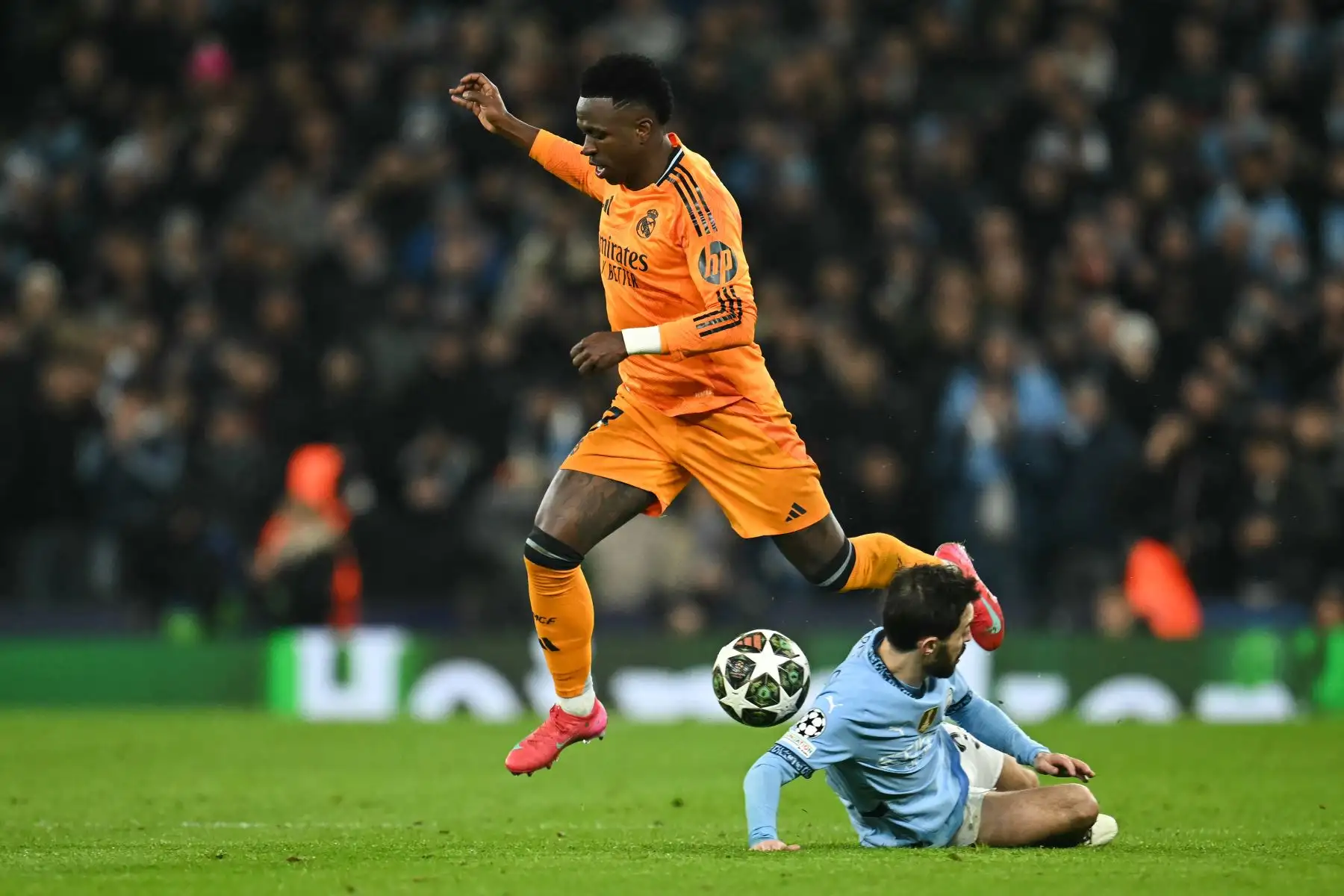 El delantero brasileño del Real Madrid, Vinicius Junior  salta sobre el centrocampista portugués del Manchester City, Bernardo Silva durante el partido de fútbol de la Liga de Campeones de la UEFA entre Manchester City y Real Madrid en el estadio Etihad de Manchester, noroeste de Inglaterra.
Foto: AFP