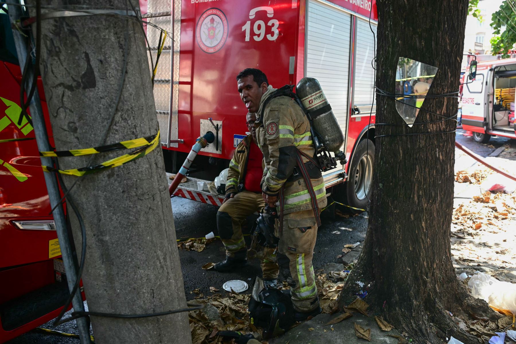 Los bomberos descansan tras apagar un incendio en una fábrica textil especializada en la confección de trajes de carnaval y uniformes policiales en la zona norte de Río de Janeiro, Brasil. Foto: AFP