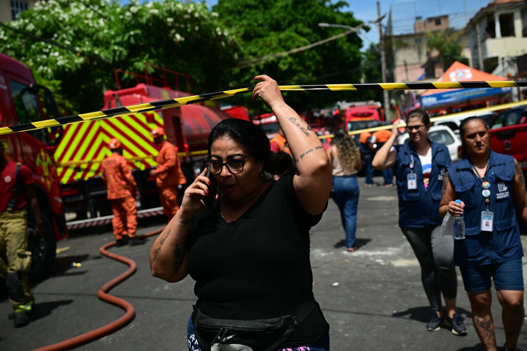 Una mujer habla por teléfono mientras espera información tras un incendio en una fábrica textil especializada en la confección de trajes de carnaval y uniformes de policía en el norte. AFP