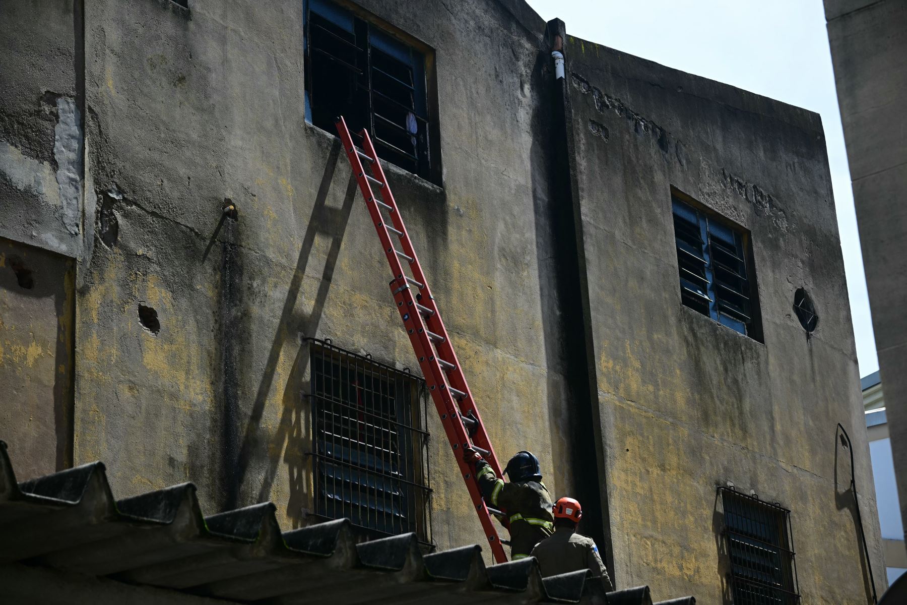 Los bomberos se marchan tras apagar un incendio en una fábrica textil especializada en la confección de trajes de carnaval y uniformes policiales en la zona norte de Río de Janeiro. AFP