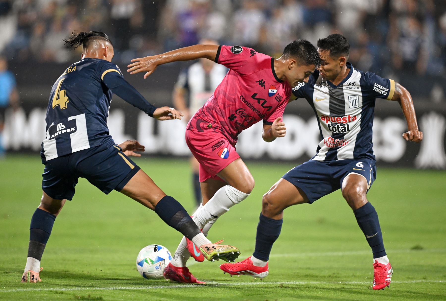 El defensor  de Alianza Lima, Erick Noriega, el defensor  Renzo Garcés y el mediocampista de Nacional  Víctor Quintana pelean por el balón durante el partido de fútbol de vuelta de la primera ronda de clasificación de la Copa Libertadores entre Alianza Lima de Perú y Nacional de Paraguay. Foto: AFP