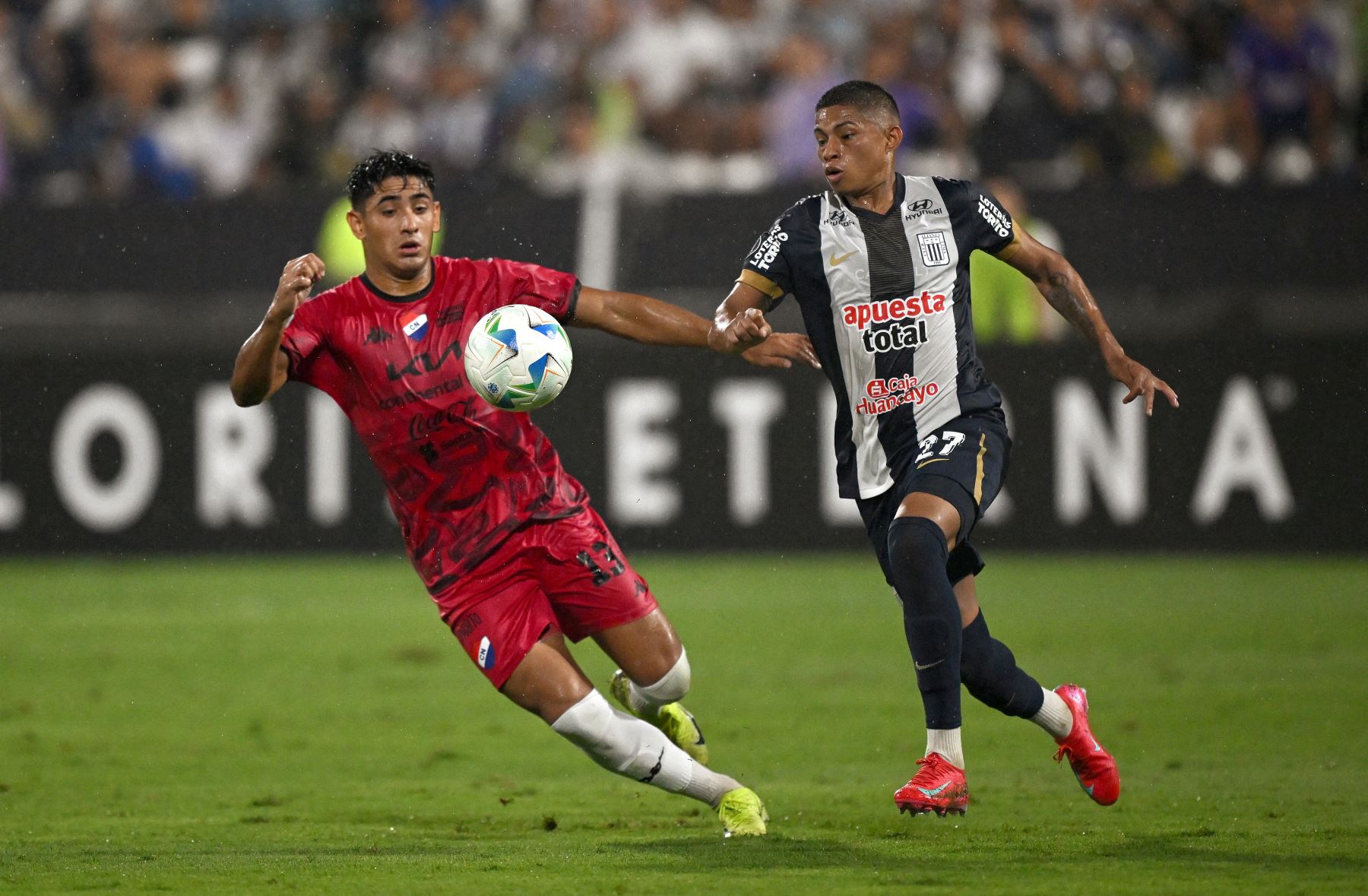 El mediocampista de Nacional #13 Leandro Meza y el delantero de Alianza Lima #27 Kevin Quevedo pelean por el balón durante el partido de fútbol de vuelta de la primera ronda de clasificación de la Copa Libertadores entre Alianza Lima de Perú y Nacional de Paraguay. AFP