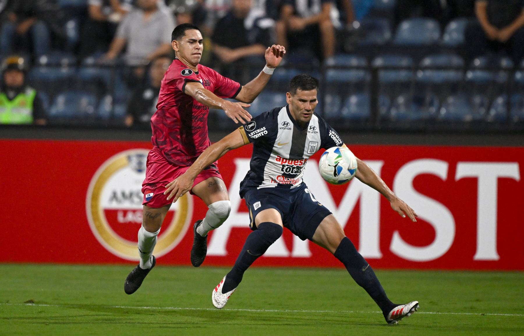 El delantero de Nacional Gustavo Caballero y el defensor argentino de Alianza Lima  Guillermo Enrique luchan por el balón durante el partido de fútbol de vuelta de la primera ronda de clasificación de la Copa Libertadores entre Alianza Lima de Perú y Nacional de Paraguay. AFP