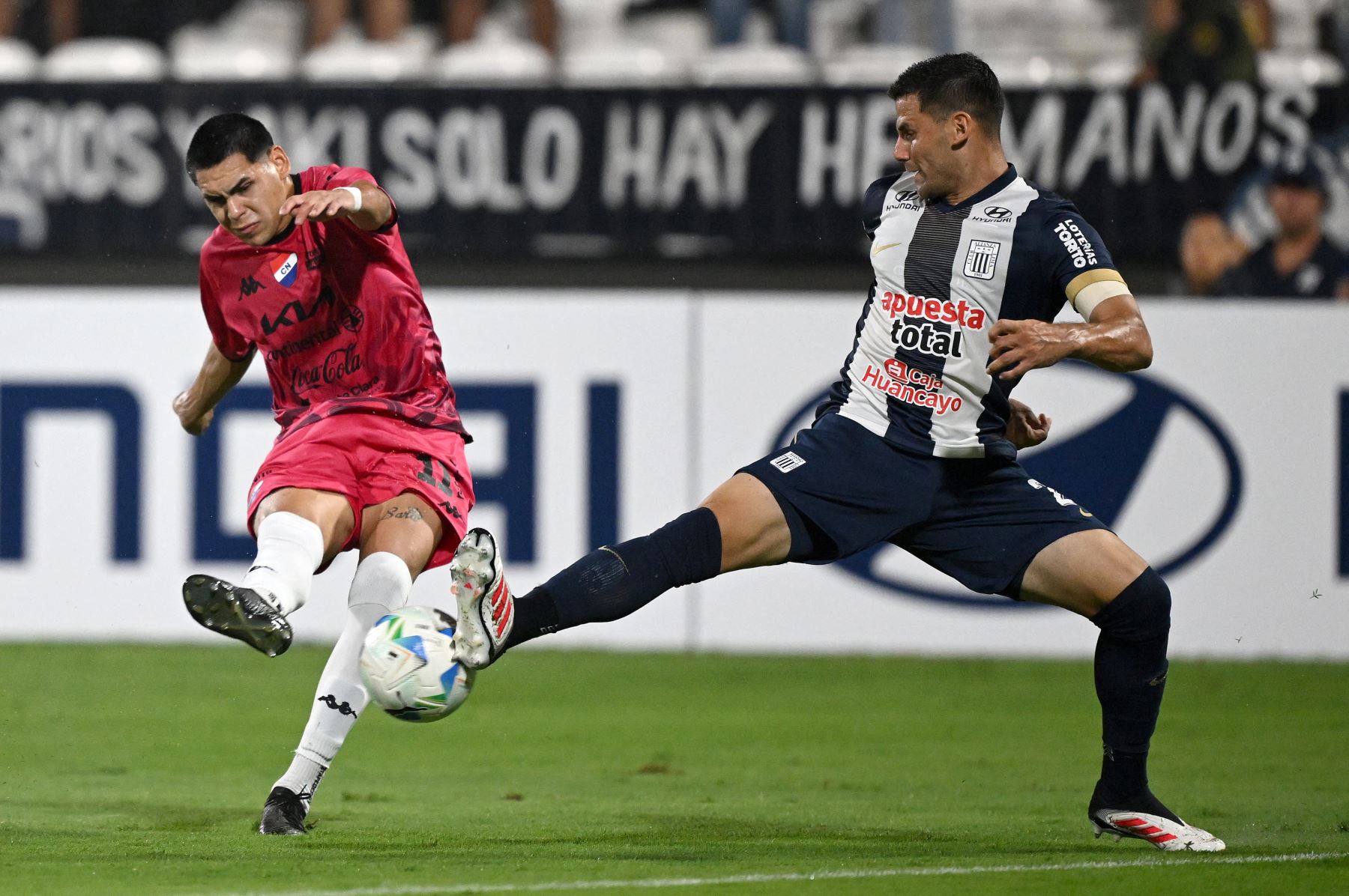 El delantero de Nacional Gustavo Caballero y el defensor argentino de Alianza Lima  Guillermo Enrique luchan por el balón durante el partido de fútbol de vuelta de la primera ronda de clasificación de la Copa Libertadores entre Alianza Lima de Perú y Nacional de Paraguay. AFP