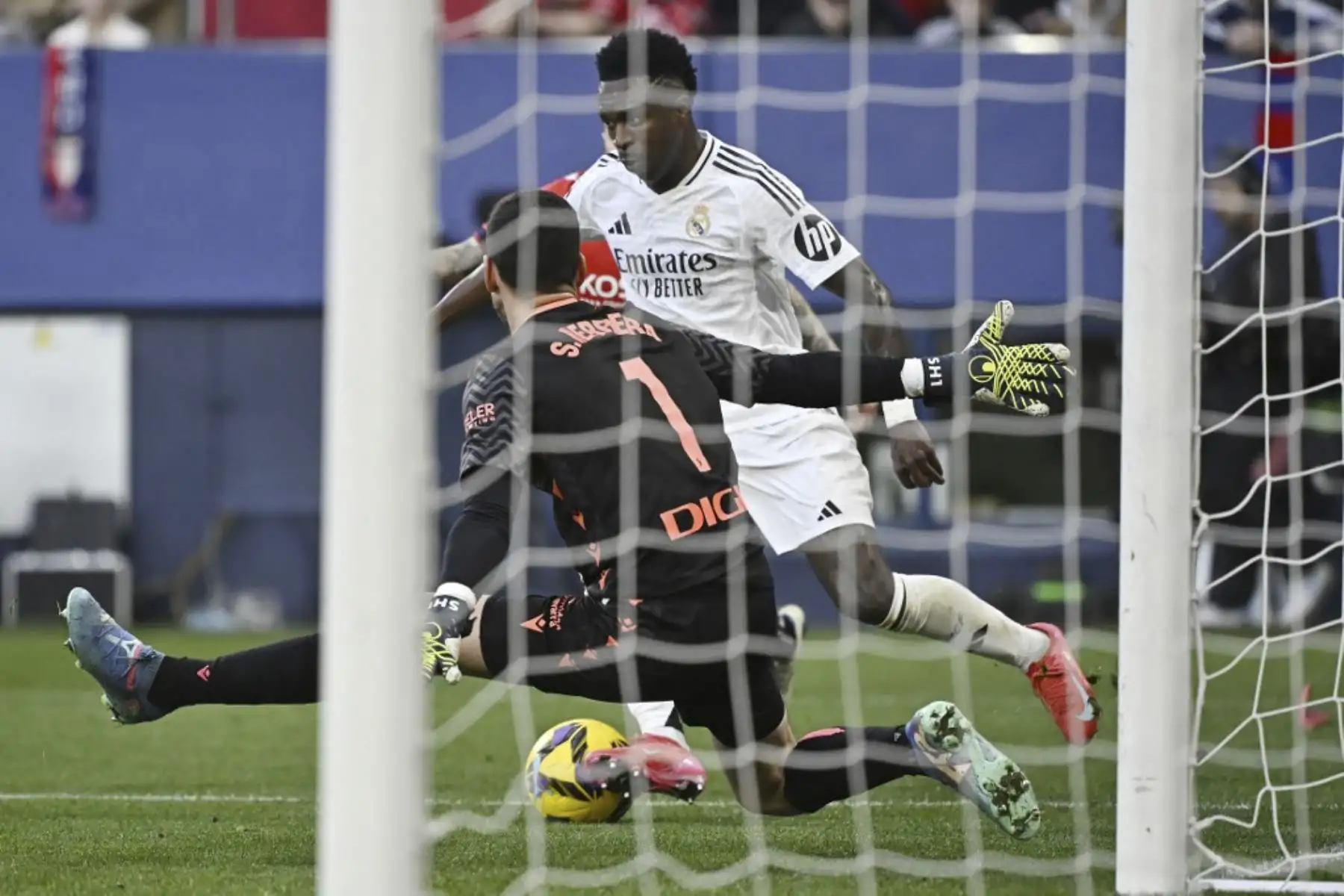 El portero español del Osasuna #01 Sergio Herrera Piron y el delantero brasileño del Real Madrid #07 Vinicius Junior compiten por el balón durante el partido de fútbol de la liga española entre CA Osasuna y Real Madrid CF en el Estadio El Sadar de Pamplona el 15 de febrero de 2025. (Foto de ANDER GILLENEA / AFP)