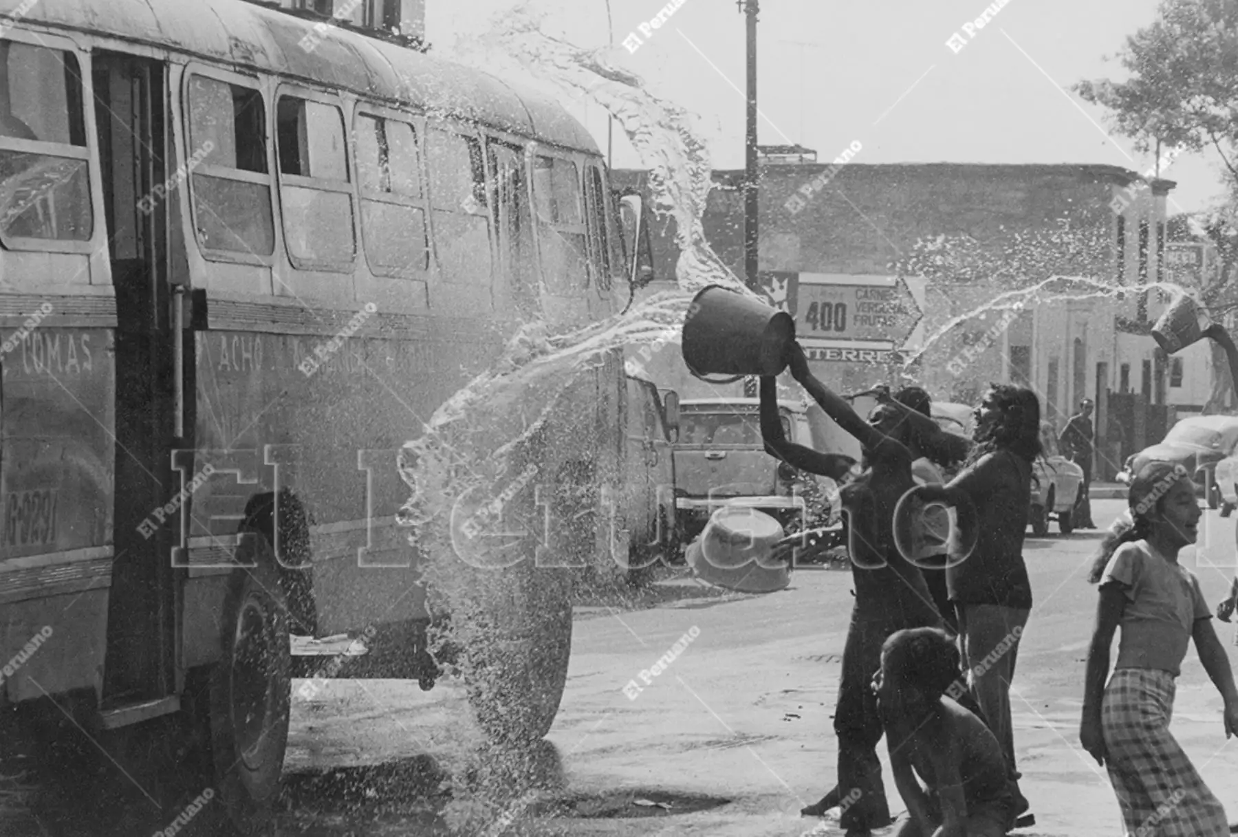 Lima - 12 febrero 1978 / Un grupo de adolescentes arrojan agua a vieja unidad de transporte público durante el segundo domingo de carnavales. Foto: Foto: Archivo Histórico El Peruano / Norman Cordova