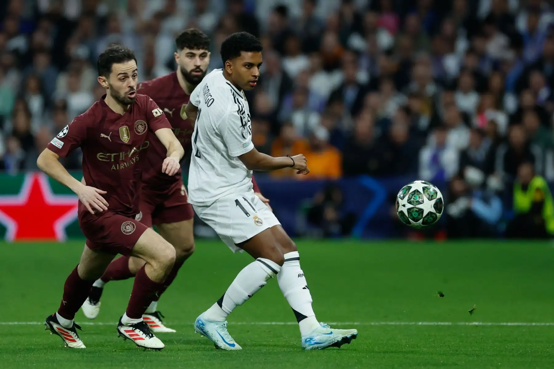 El jugador del Real Madrid Rodrygo Goes en acción contra el jugador del Manchester City Bernardo Silva durante el partido de vuelta de los play-offs de la UEFA Champions League entre el Real Madrid y el Manchester City. Foto: ANDINA/EFE