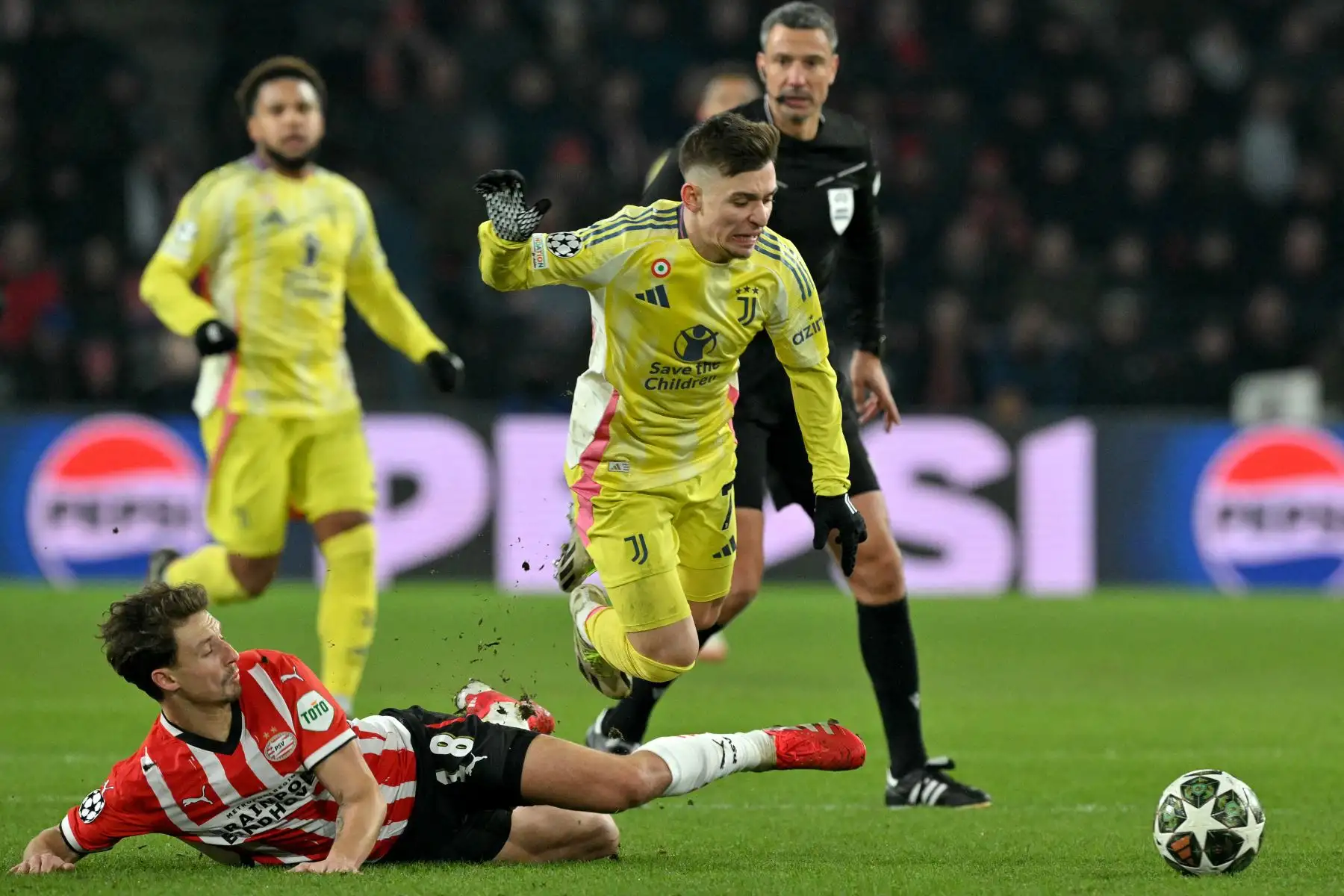 El delantero portugués de la Juventus, Francisco Conceicao, es tackleado por el defensor francés  del PSV Eindhoven, Olivier Boscagli, durante el partido de vuelta de los play-offs de la fase eliminatoria de la UEFA Champions League entre el PSV Eindhoven y la Juventus. 
Foto: ANDINA/AFP