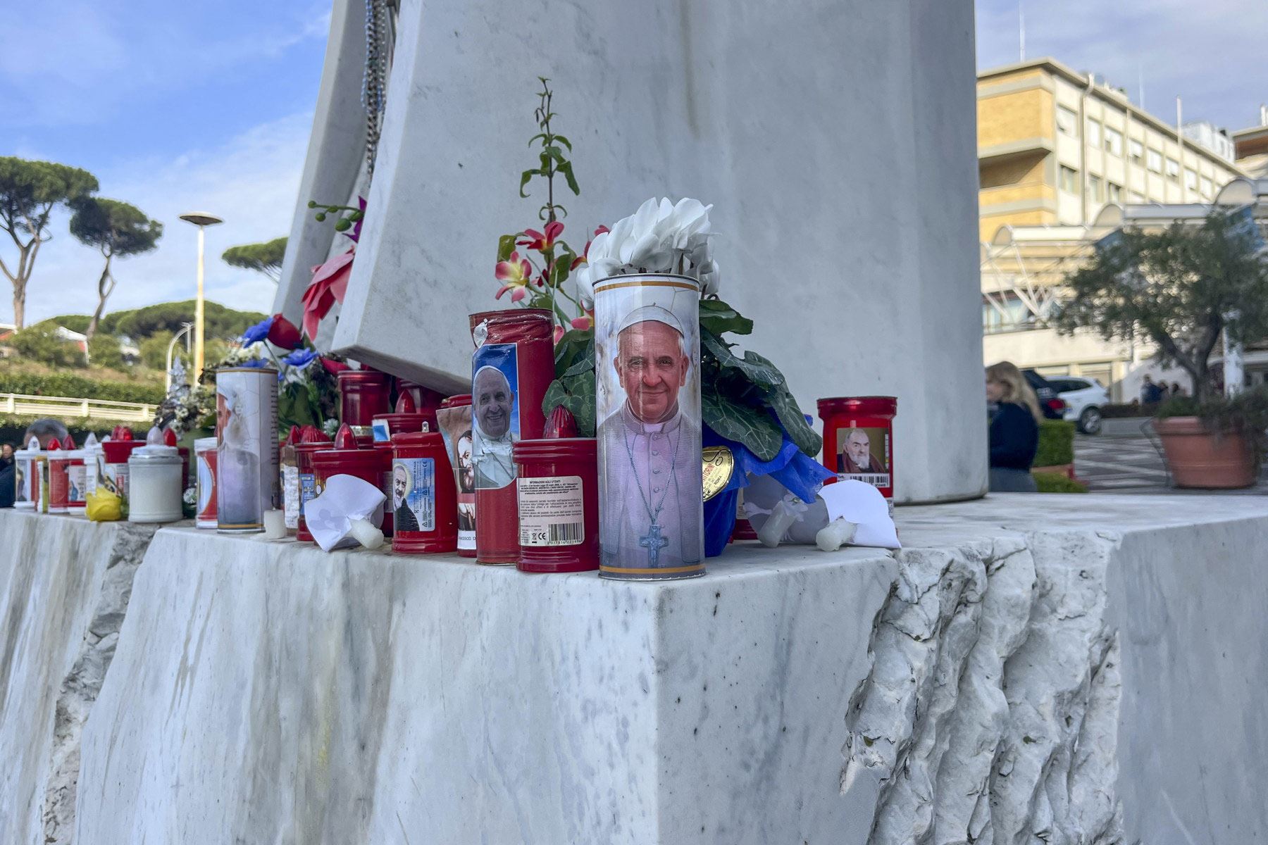 Flores y velas depositadas por feligreses, fotografiadas este jueves en el exterior del Hospital Gemelli de Roma, donde se encuentra hospitalizado desde hace siete días el papa Francisco debido a una infección de las vías respiratorias y una neumonía bilateral. Foto: EFE