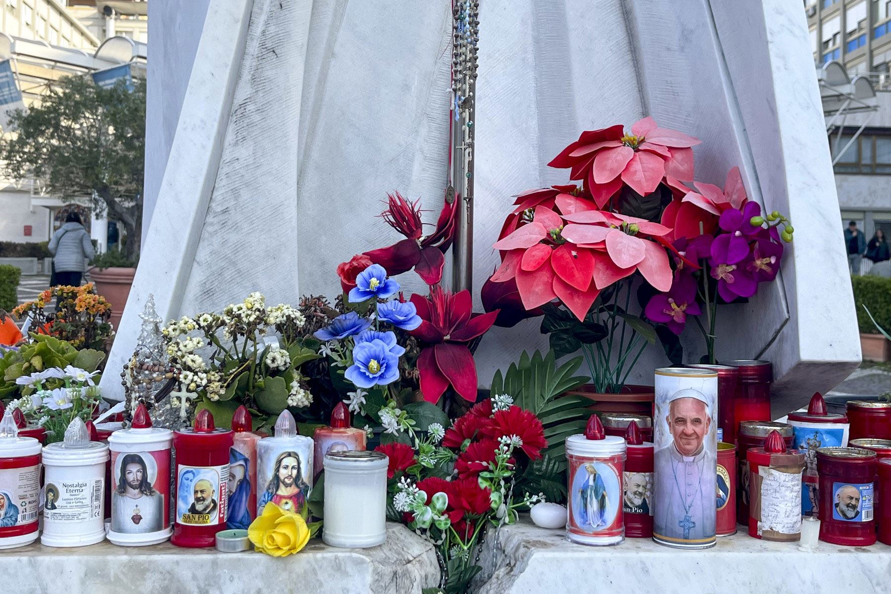 Flores y velas depositadas por feligreses, fotografiadas este jueves en el exterior del Hospital Gemelli de Roma, donde se encuentra hospitalizado desde hace siete días el papa Francisco debido a una infección de las vías respiratorias y una neumonía bilateral. Foto: EFE