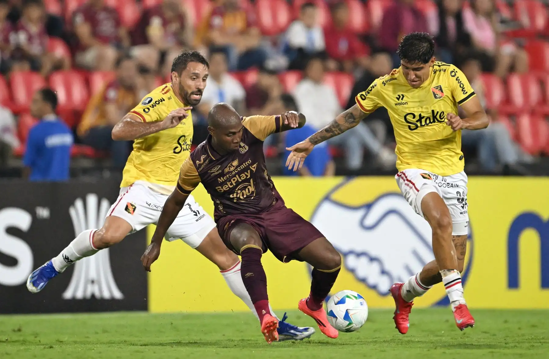 El mediocampista del Tolima  Samuel Velásquez  el delantero argentino de Melgar  Cristian Bordacahar  y el mediocampista  Gian Carlo García luchan por el balón durante el partido de fútbol de ida de la segunda ronda de clasificación de la Copa Libertadores entre Deportes Tolima de Colombia y Melgar de Perú. AFP