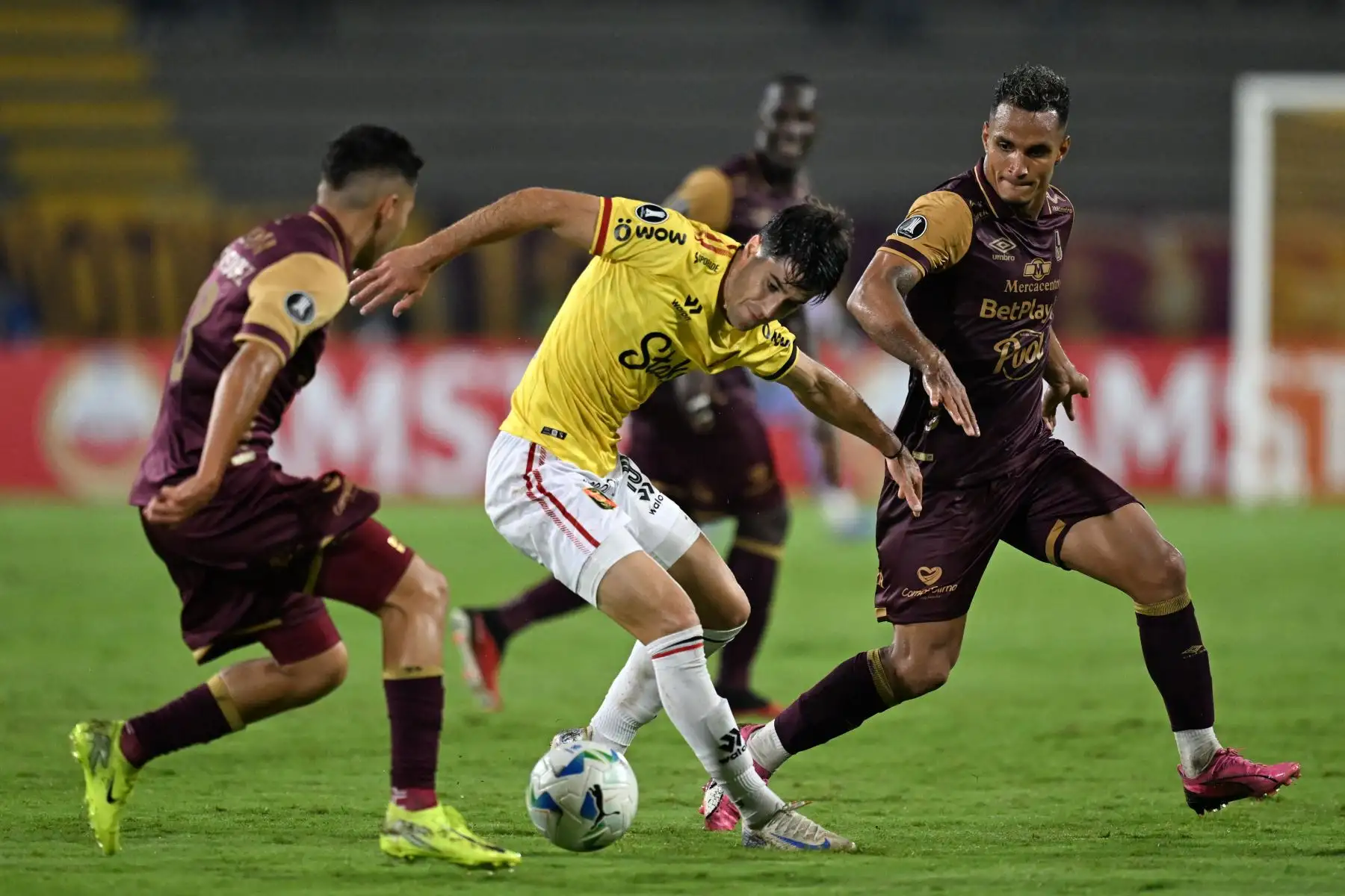 El delantero argentino de Melgar  Gregorio Rodríguez pelea por el balón con el mediocampista de Tolima  Samuel Velásquez  y el mediocampista #80 Brayan Rovira durante el partido de fútbol de ida de segunda ronda de clasificación para la Copa Libertadores entre Deportes Tolima de Colombia y Melgar de Perú. AFP