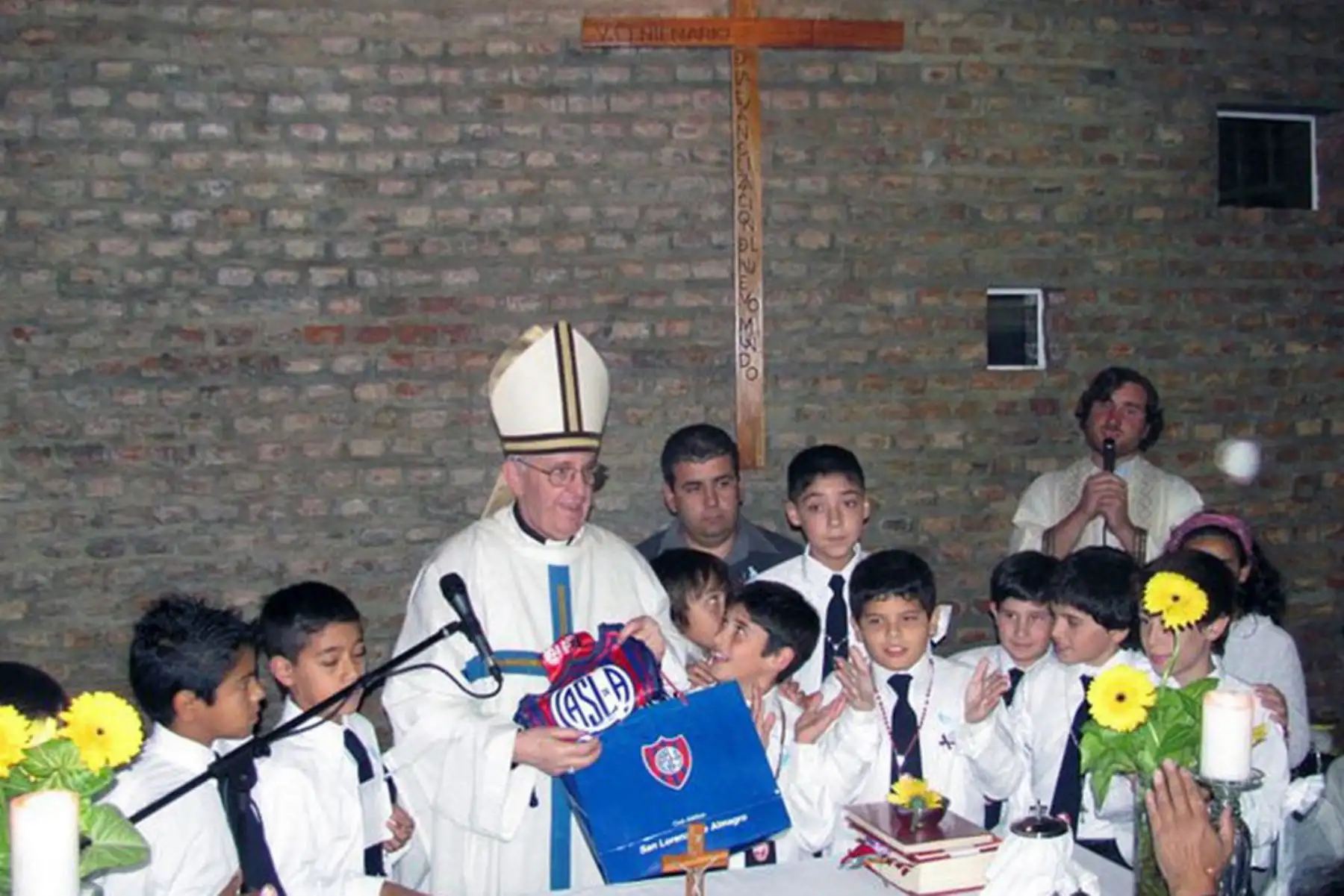 Foto de archivo del cardenal argentino Jorge Mario Bergoglio posando con niños de una escuela y el emblema del equipo de fútbol San Lorenzo, del que es hincha, en Buenos Aires. Bergoglio fue elegido Papa el 13 de marzo de 2013. Foto: AFP