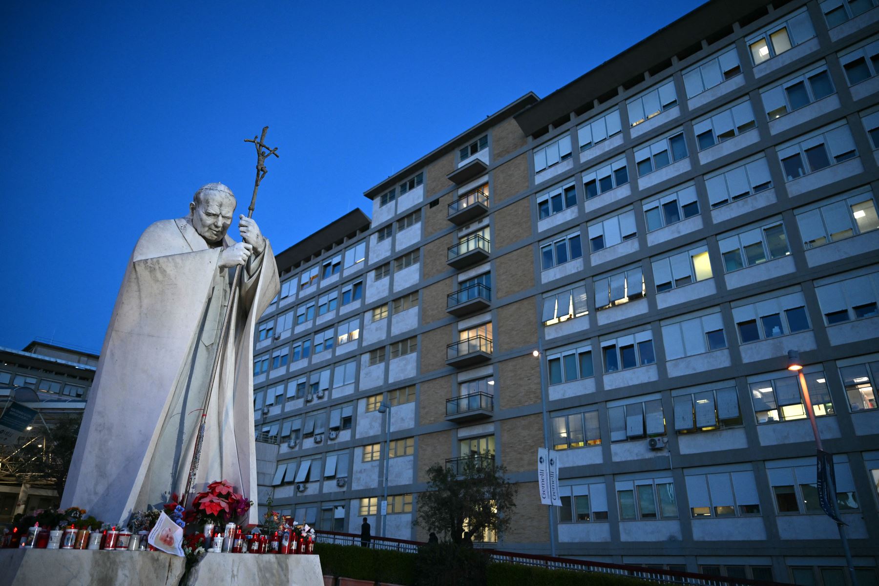 Se colocan velas en la estatua de Juan Pablo II afuera del hospital Gemelli donde el Papa Francisco está hospitalizado en Roma.
Foto: AFP