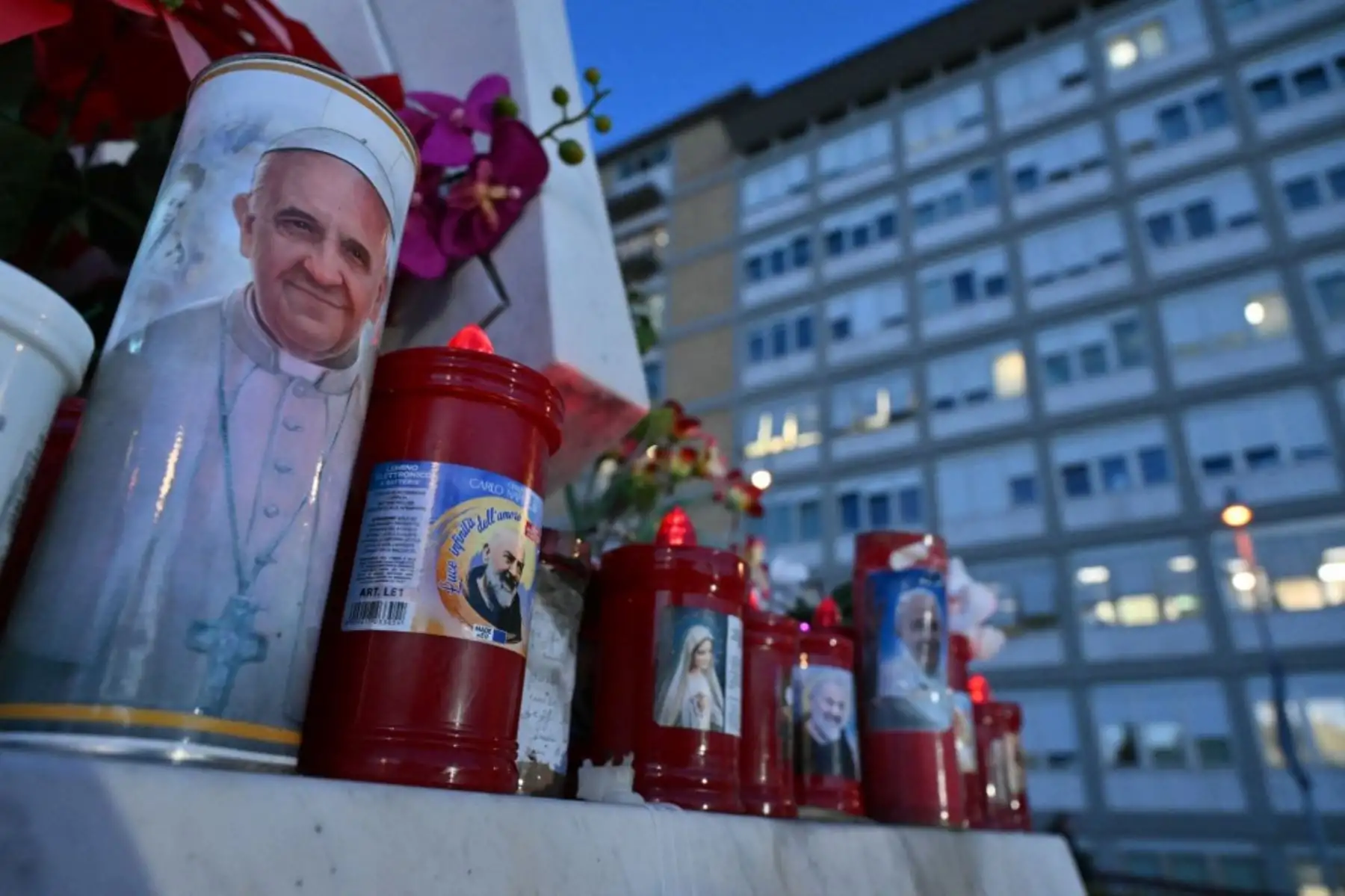 Se colocan velas en la estatua de Juan Pablo II fuera del hospital Gemelli, donde el Papa Francisco está hospitalizado en Roma el 22 de febrero de 2025. El Papa Francisco pasa otra noche tranquila en el hospital, dijo el Vaticano el 21 de febrero de 2025 en su actualización matutina, ya que el hombre de 88 años pasó su séptimo día en el hospital siendo tratado por neumonía. (Foto de Alberto PIZZOLI / AFP)