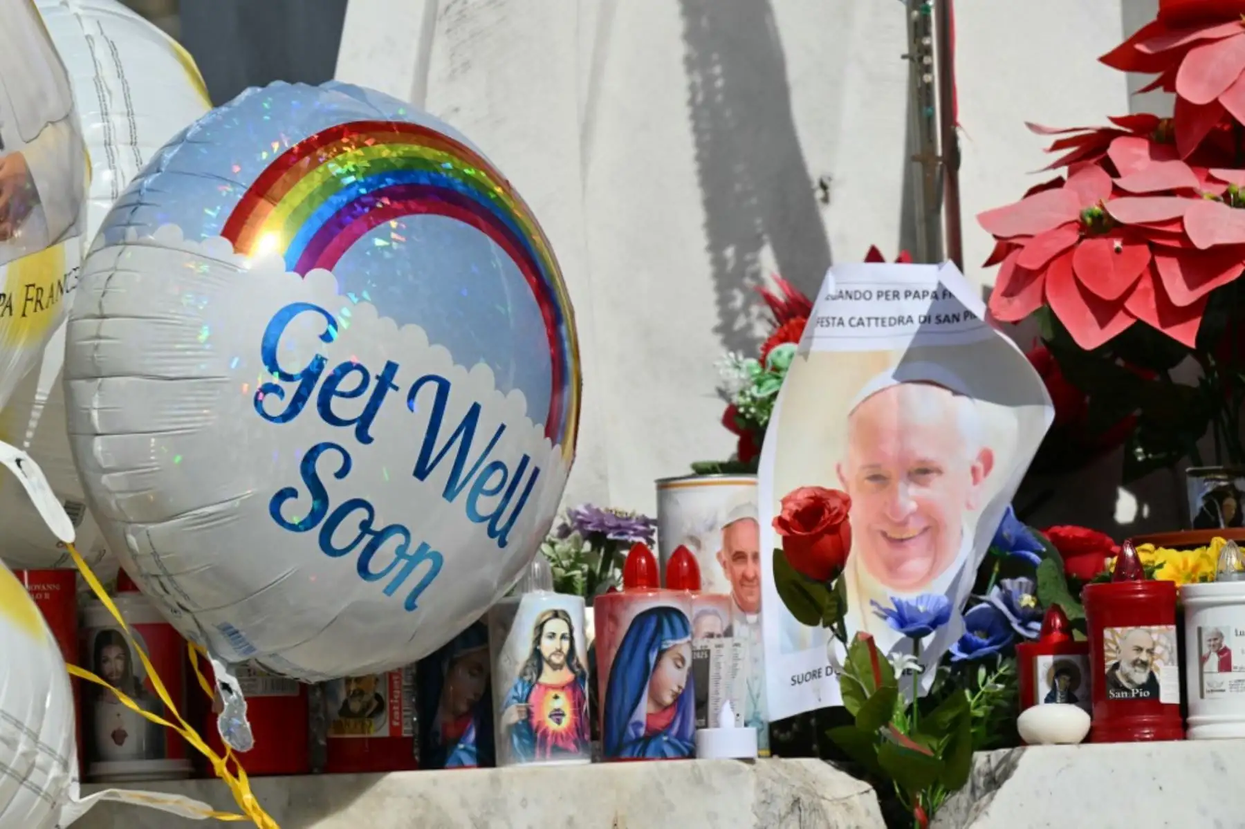 Fieles colocan globos junto a la estatua de Juan Pablo II donde la gente viene a rezar fuera del hospital Gemelli donde el Papa Francisco está hospitalizado por neumonía, en Roma el 23 de febrero de 2025. El Papa Francisco tuvo una noche tranquila en el hospital, dijo el Vaticano el 23 de febrero de 2025, la mañana después de revelar que el hombre de 88 años se encontraba en un estado "crítico". "La noche pasó pacíficamente, el Papa descansó", dijo la Santa Sede en una breve actualización. (Foto de Alberto PIZZ