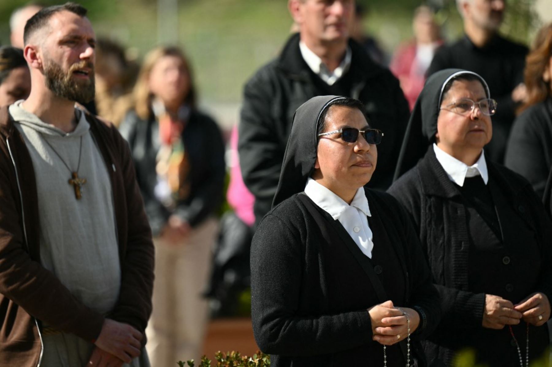 Monjas rezan en la estatua de Juan Pablo II fuera del hospital Gemelli, donde el Papa Francisco está hospitalizado por neumonía, en Roma el 23 de febrero de 2025. El Papa Francisco tuvo una noche tranquila en el hospital, dijo el Vaticano el 23 de febrero de 2025, la mañana después de revelar que el hombre de 88 años se encontraba en un estado "crítico". "La noche pasó pacíficamente, el Papa descansó", dijo la Santa Sede en una breve actualización. (Foto de Alberto PIZZOLI / AFP)