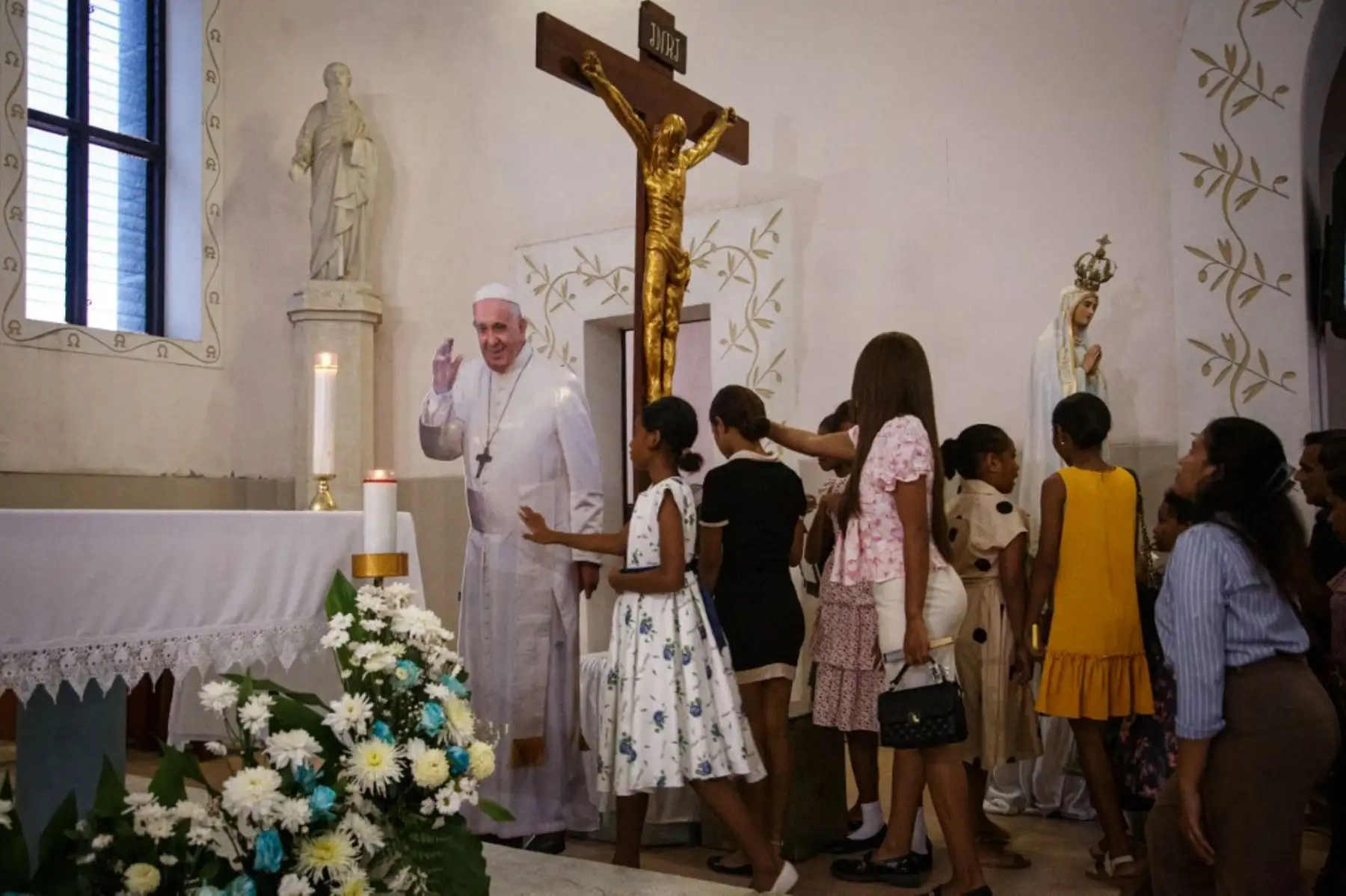 Católicos se reúnen para tocar un recorte de cartón de tamaño natural del Papa Francisco, que actualmente está hospitalizado en Roma por neumonía, durante la misa dominical en la Iglesia de Santo Antonio de Motael en Dili, Timor Oriental, el 23 de febrero de 2025. (Foto de VALENTINO DARIELL DE SOUSA / AFP)