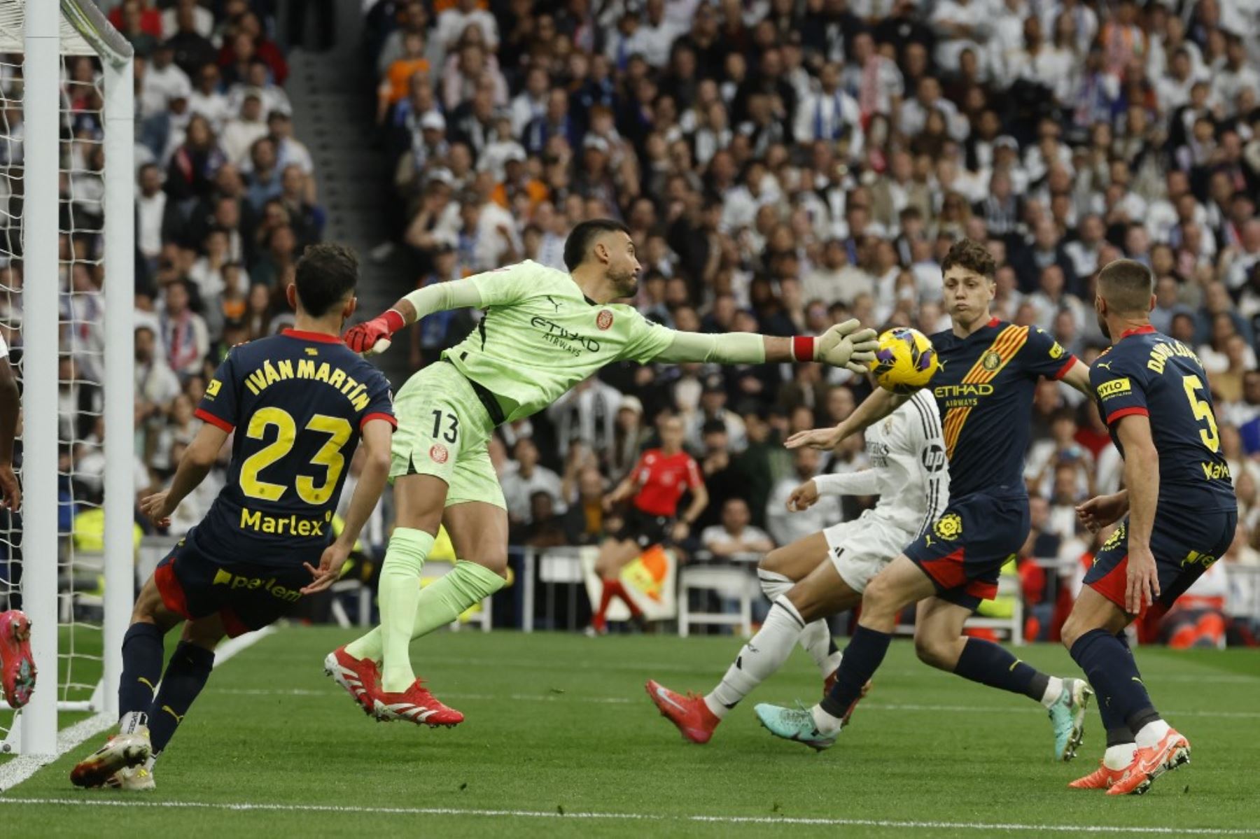 El portero argentino del Girona #13 Paulo Gazzaniga salva el balón durante el partido de fútbol de la liga española entre el Real Madrid CF y el Girona FC en el Estadio Santiago Bernabéu de Madrid el 23 de febrero de 2025. (Foto de Pierre-Philippe MARCOU / AFP)