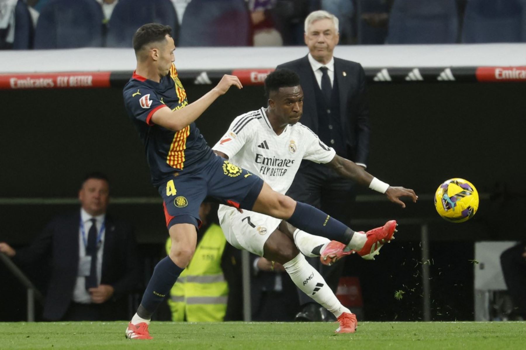 El centrocampista español del Girona #04, Arnau Martínez, desafía al delantero brasileño del Real Madrid #07 Vinicius Junior durante el partido de fútbol de la liga española entre el Real Madrid CF y el Girona FC en el Estadio Santiago Bernabéu de Madrid el 23 de febrero de 2025. (Foto de Pierre-Philippe MARCOU / AFP)